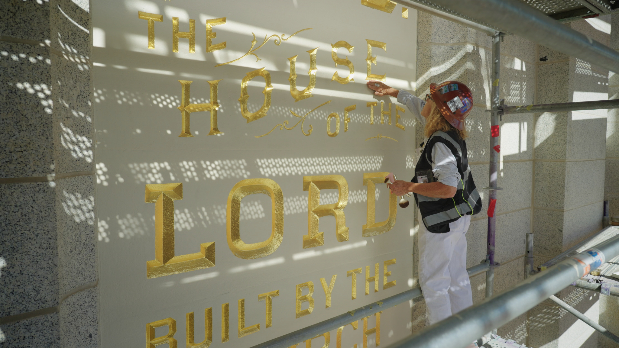 Anne Domenech, an artist with Evergreen, works to restore the "Holiness to the Lord" panel on the Salt Lake Temple of The Church of Jesus Christ of Latter-day Saints on Aug. 19.