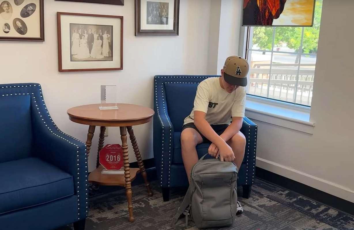 A student accesses his cellphone in the front office, Thursday. Despite the implementation of a new cellphone policy, children can still use it to call their parents in an emergency.