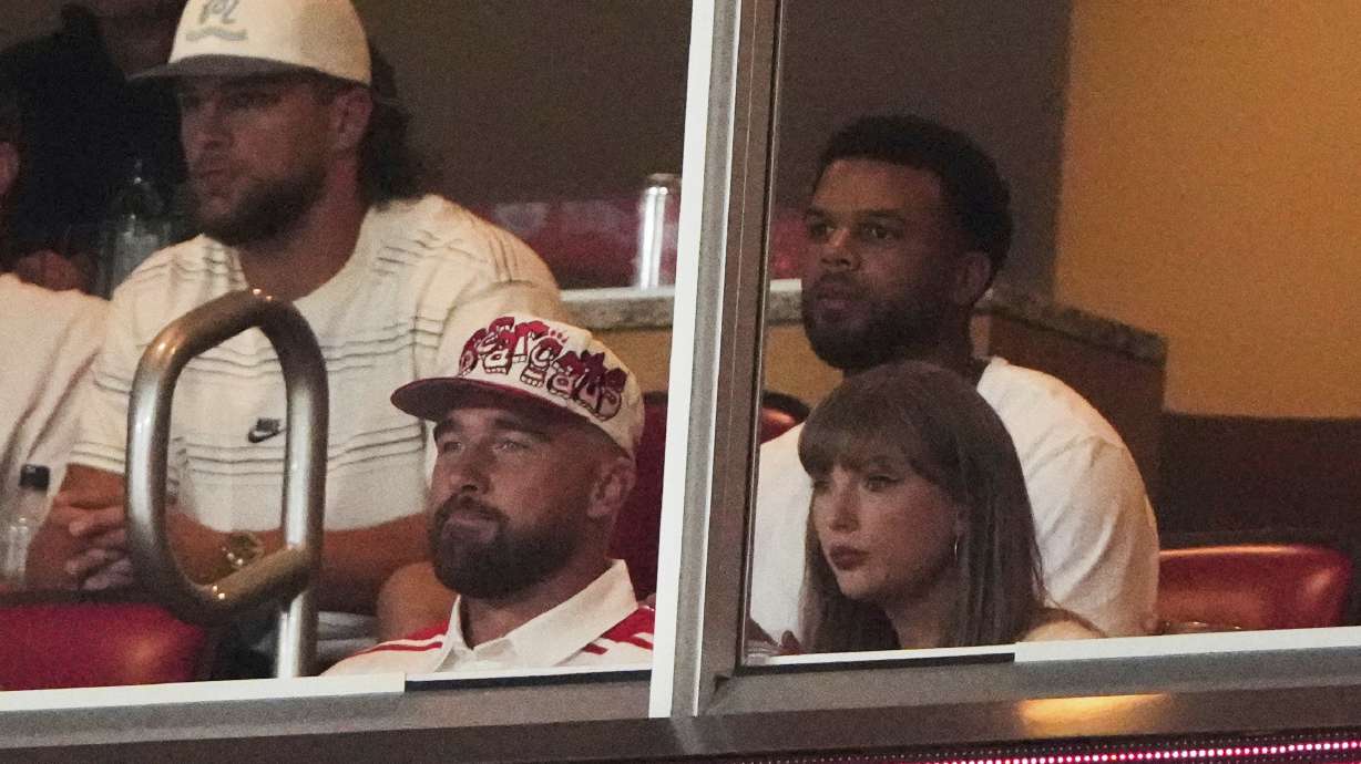 Taylor Swift, front right, sits with fiance Travis Kelce, second from front left, as they watch the first half of an NCAA college football game between Cincinnati and Nebraska, Thursday, Aug. 28, 2025, at Arrowhead Stadium in Kansas City, Mo.