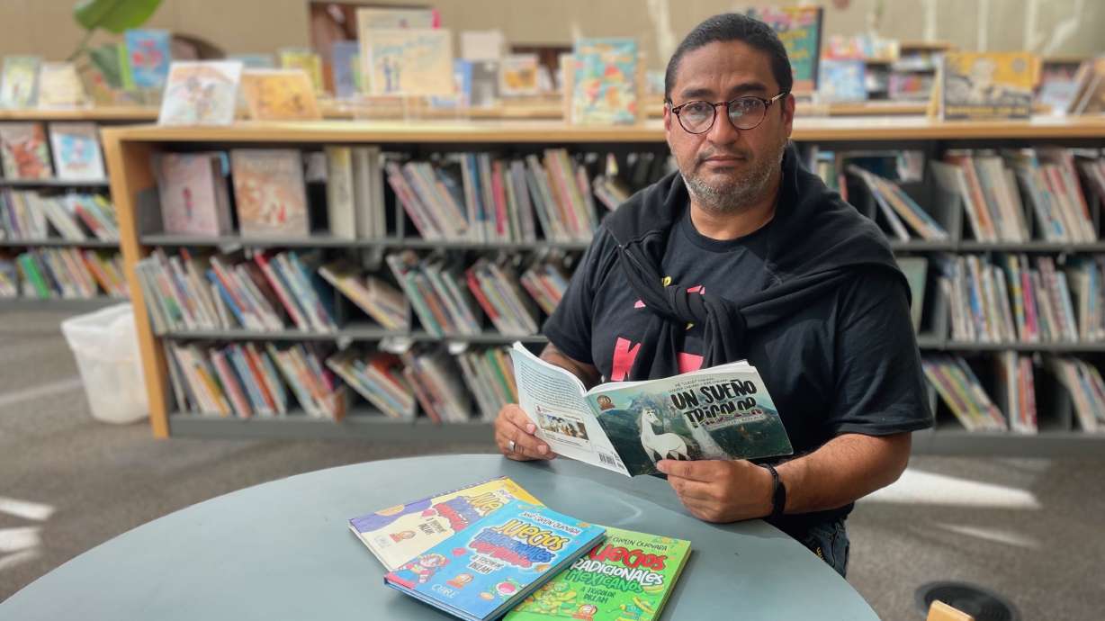 José Guevara, photographed Aug. 13, at the Salt Lake City Public Library, with some of the books published through his nonprofit venture, Capitán Zarigüeya Publishing Fund, which is meant to connect Latino kids with their roots.