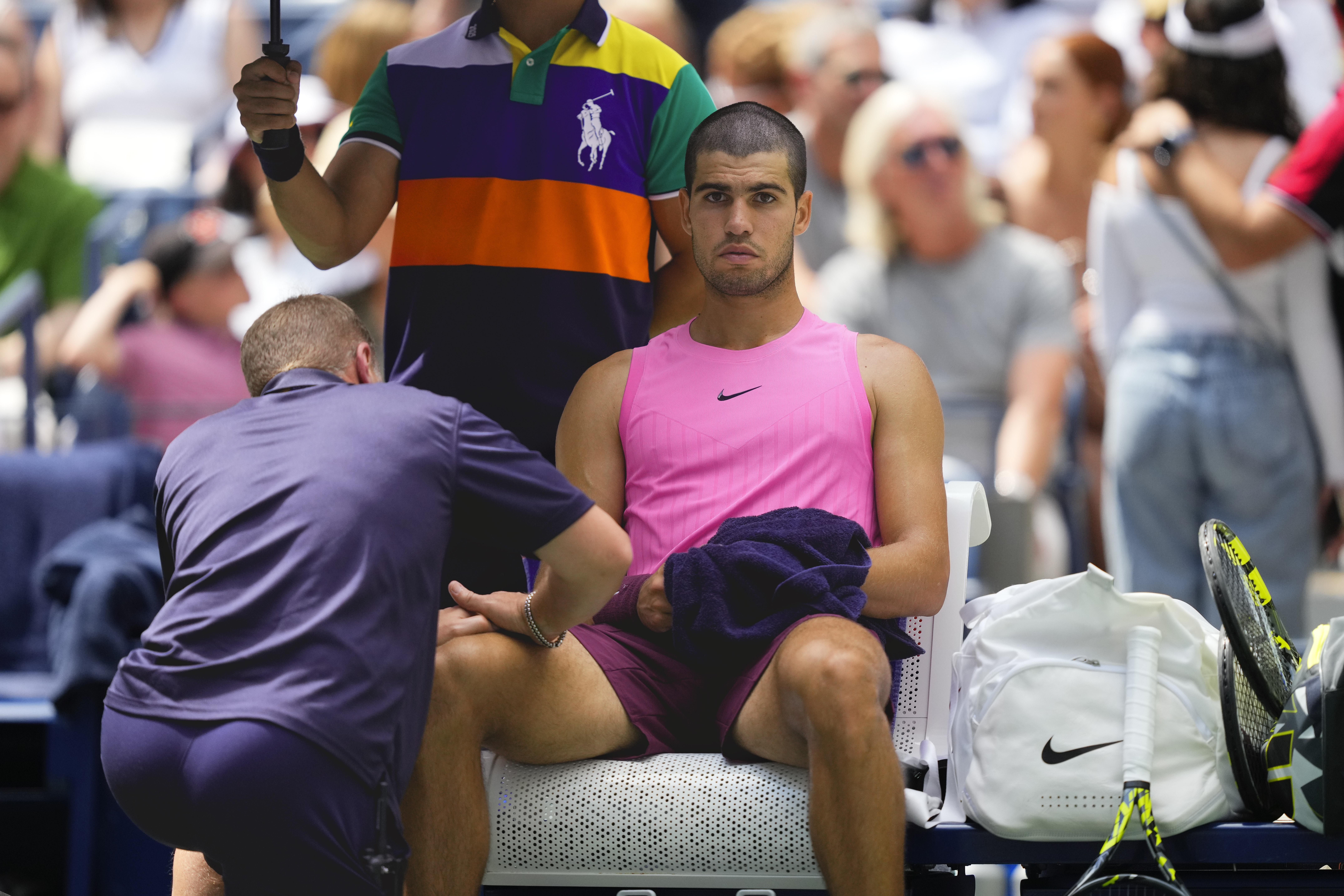 A trainer works on Carlos Alcaraz, of Spain, during a medical timeout in the second set against Luciano Darderi, of Italy, during the third round of the U.S. Open tennis championships, Friday, Aug. 29, 2025, in New York. 