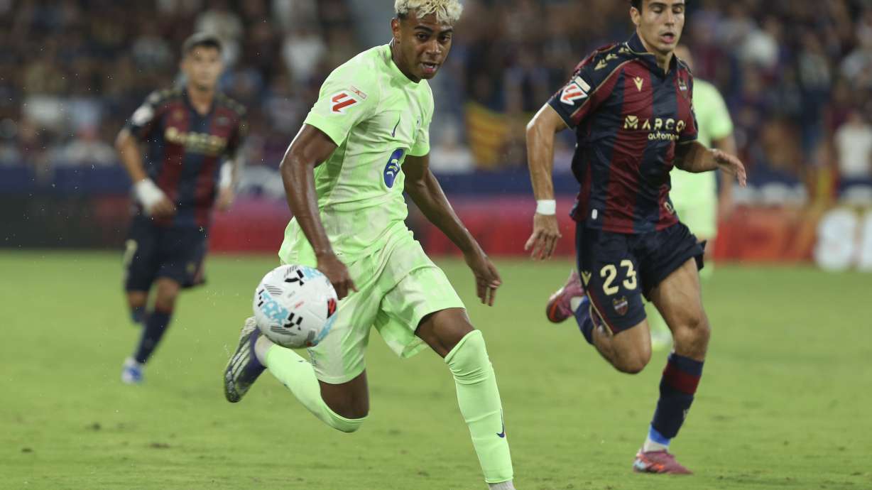 Barcelona's Lamine Yamal, left, and Levantes' Pablo Martinez run for the ball during the La Liga soccer match between Levante and Barcelon in Valencia, Spain, Saturday, Aug. 23, 2025.