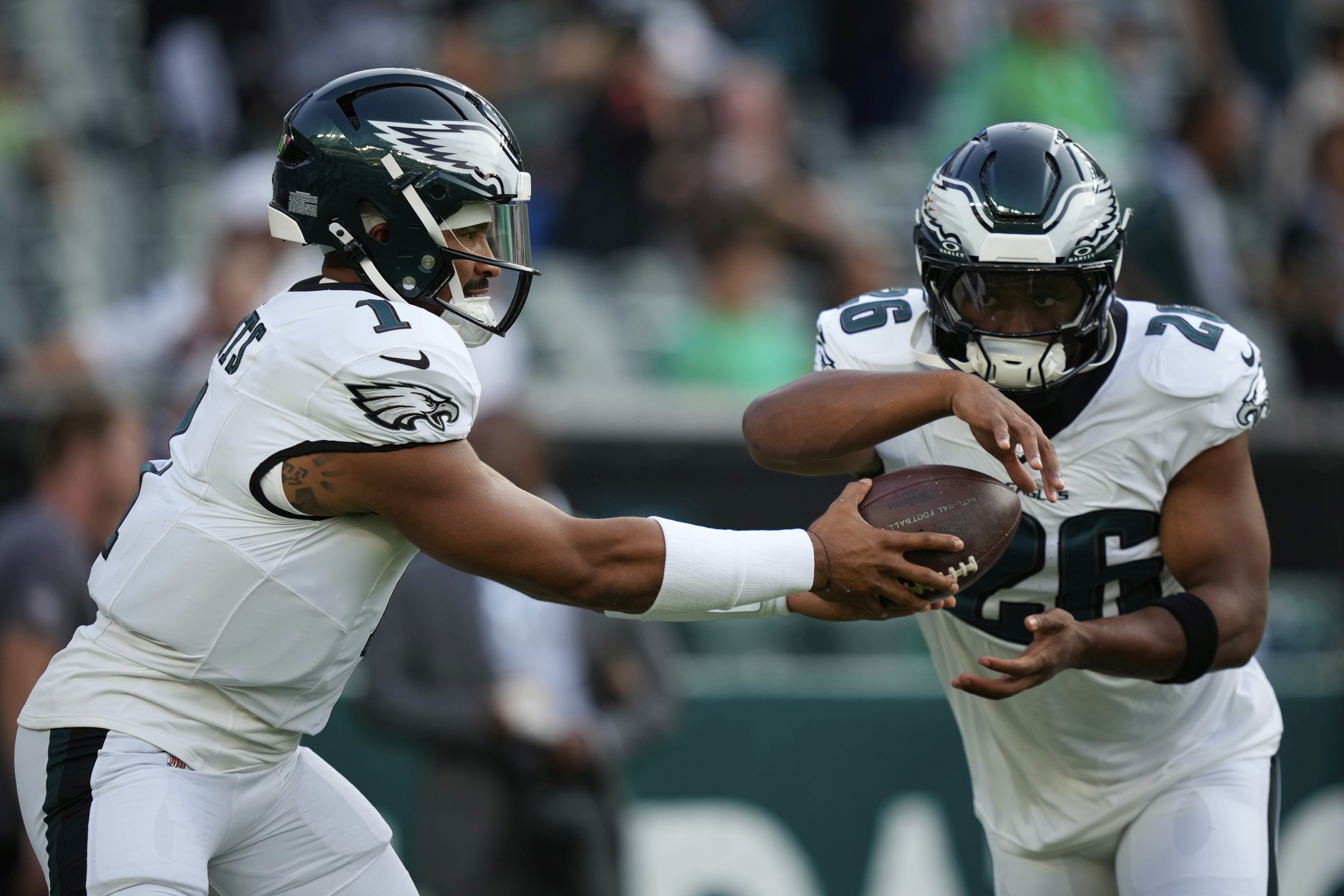 Philadelphia Eagles quarterback Jalen Hurts (1) hands off to Eagles running back Saquon Barkley (26) during warm ups before an NFL preseason football game against the Cincinnati Bengals on Thursday, Aug. 7, 2025, in Philadelphia. 