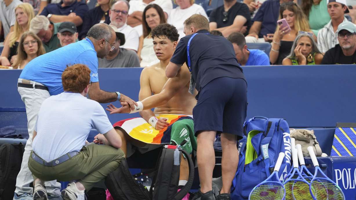 Trainers work on Ben Shelton, of the United States, during a break in play against Adrian Mannarino, of France, during the third round of the U.S. Open tennis championships, Friday, Aug. 29, 2025, in New York.