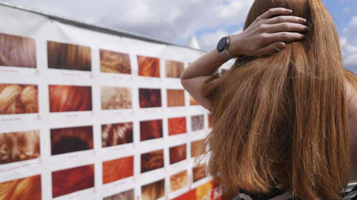 A participant checks her hair color on a chart of gradations of red during the Red Head Days festival in Tilburg, Netherlands, Saturday.