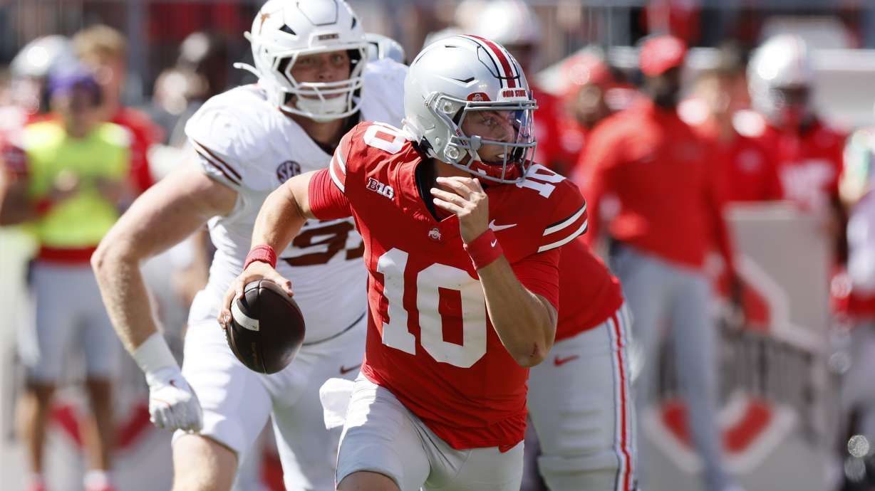 Ohio State quarterback Julian Sayin is chased out of the pocket by Texas defensive lineman Ethan Burke during the second half of an NCAA college football game, Saturday, Aug. 30, 2025, in Columbus, Ohio.