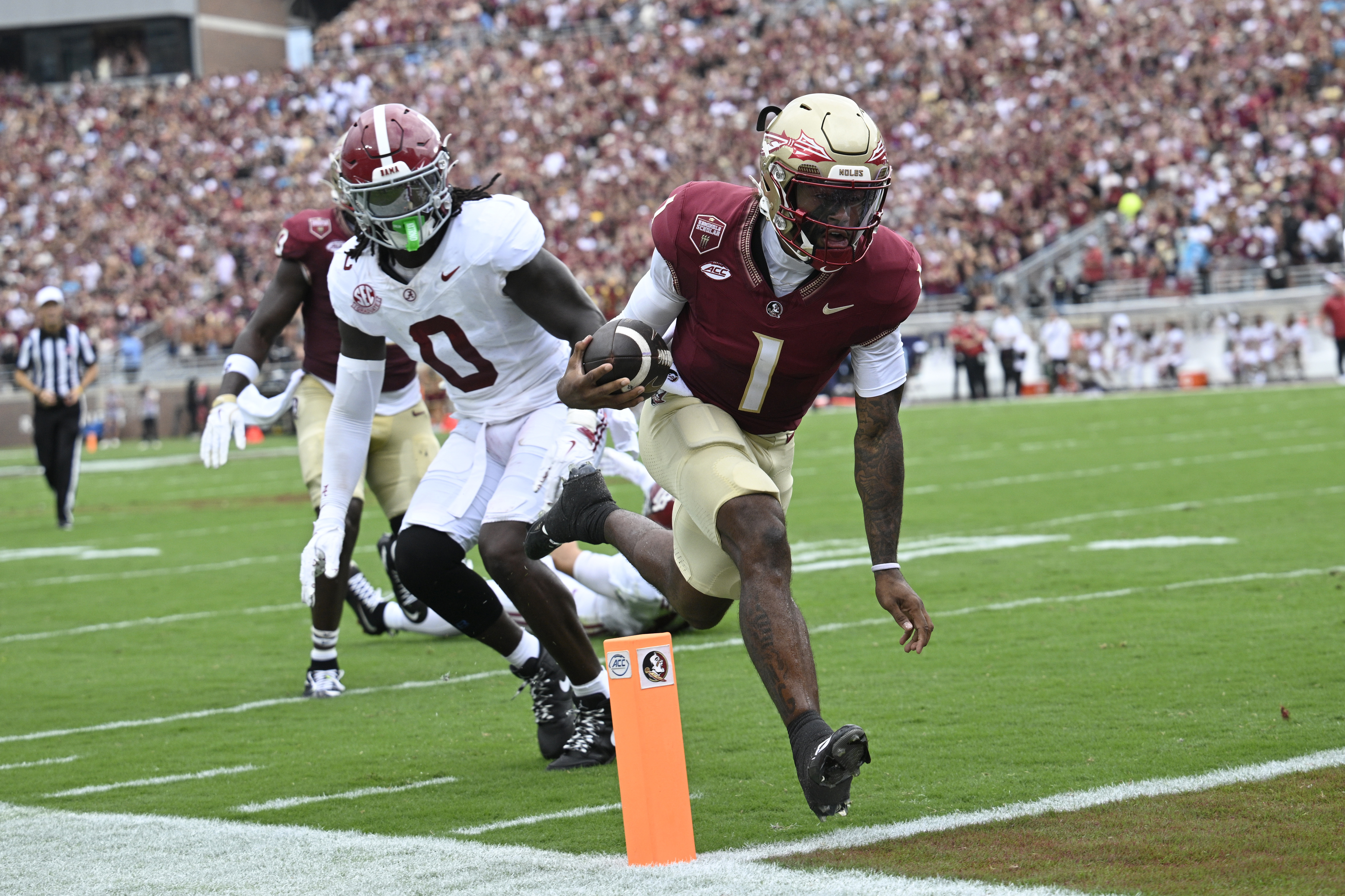 Florida State quarterback Tommy Castellanos (1) scores a 9-yard rushing touchdown past Alabama linebacker Deontae Lawson (0) during the first half of an NCAA college football game, Saturday, Aug. 30, 2025, in Tallahassee, Fla.