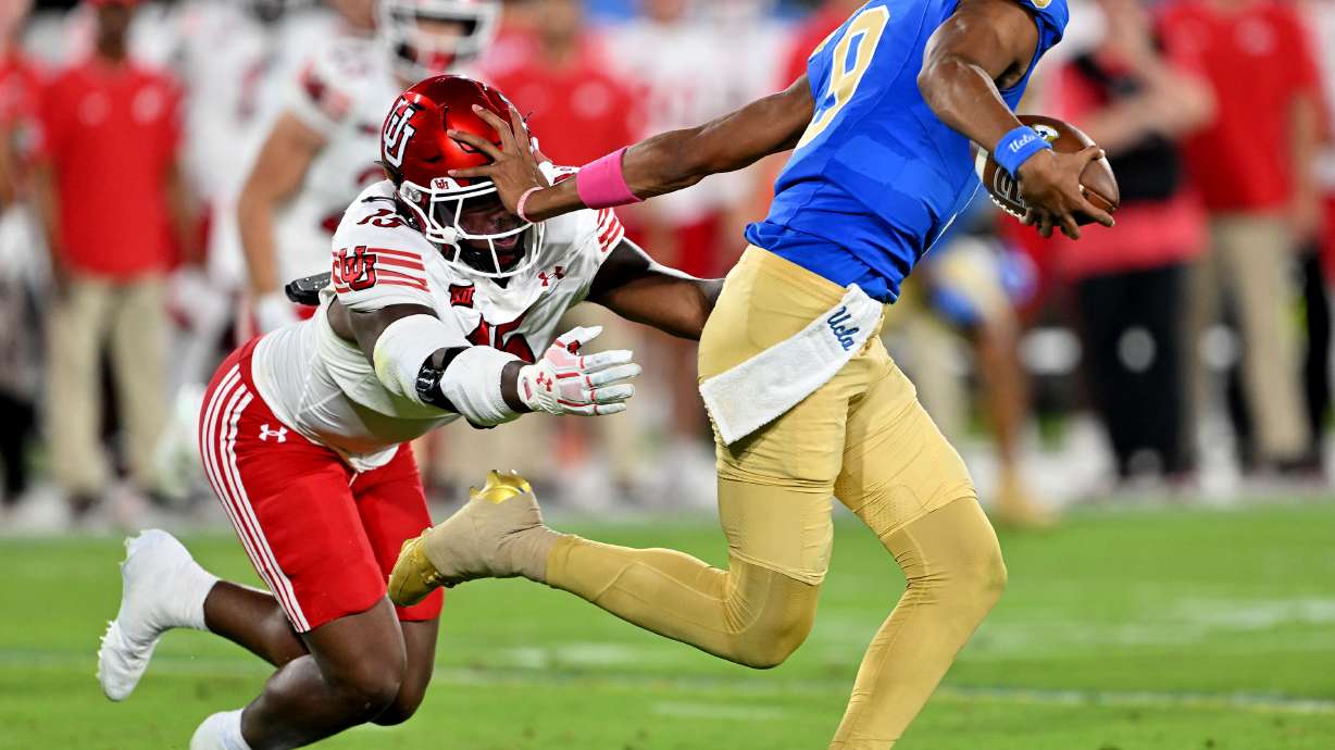 Utah Utes defensive end Lance Holtzclaw (15) gets stiff-armed by UCLA Bruins quarterback Nico Iamaleava (9) as they play at the Rose Bowl in Pasadena, Calif., on Saturday, Aug. 30, 2025.