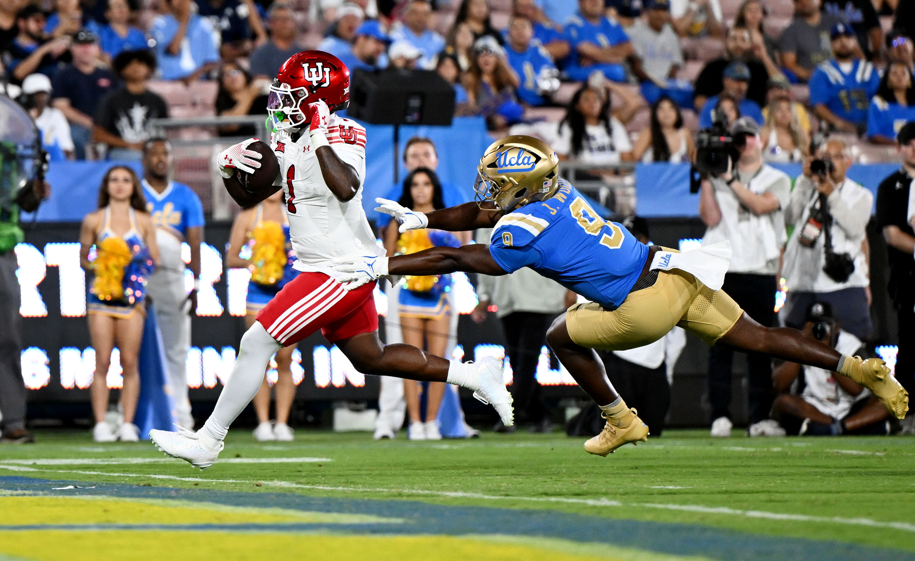 Utah Utes running back Wayshawn Parker (1) runs in for a touchdown ahead of UCLA Bruins linebacker Jalen Woods (9) as Utah and UCLA play at the Rose Bowl in Pasadena, Calif., on Saturday, Aug. 30, 2025.