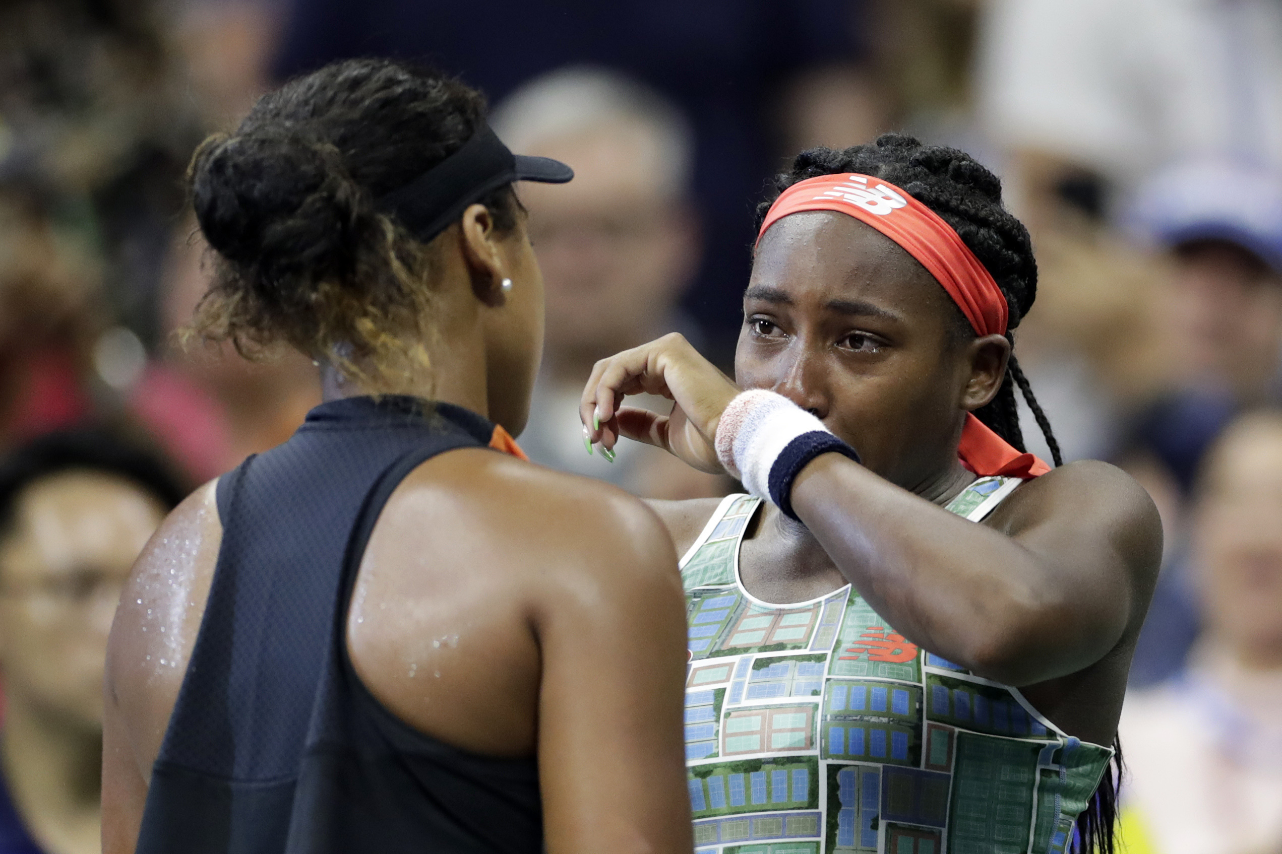 FILE - Coco Gauff, right, of the United States, wipes away tears while talking to Naomi Osaka, of Japan, after Osaka defeated Gauff in the third round of the U.S. Open tennis tournament Saturday, Aug. 31, 2019, in New York. 