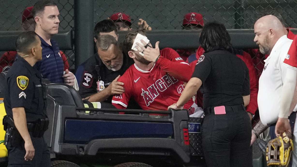 Los Angeles Angels left fielder Taylor Ward, center, is treated for injury during the eighth inning of a baseball game against the Houston Astros in Houston, Sunday, Aug. 31, 2025.