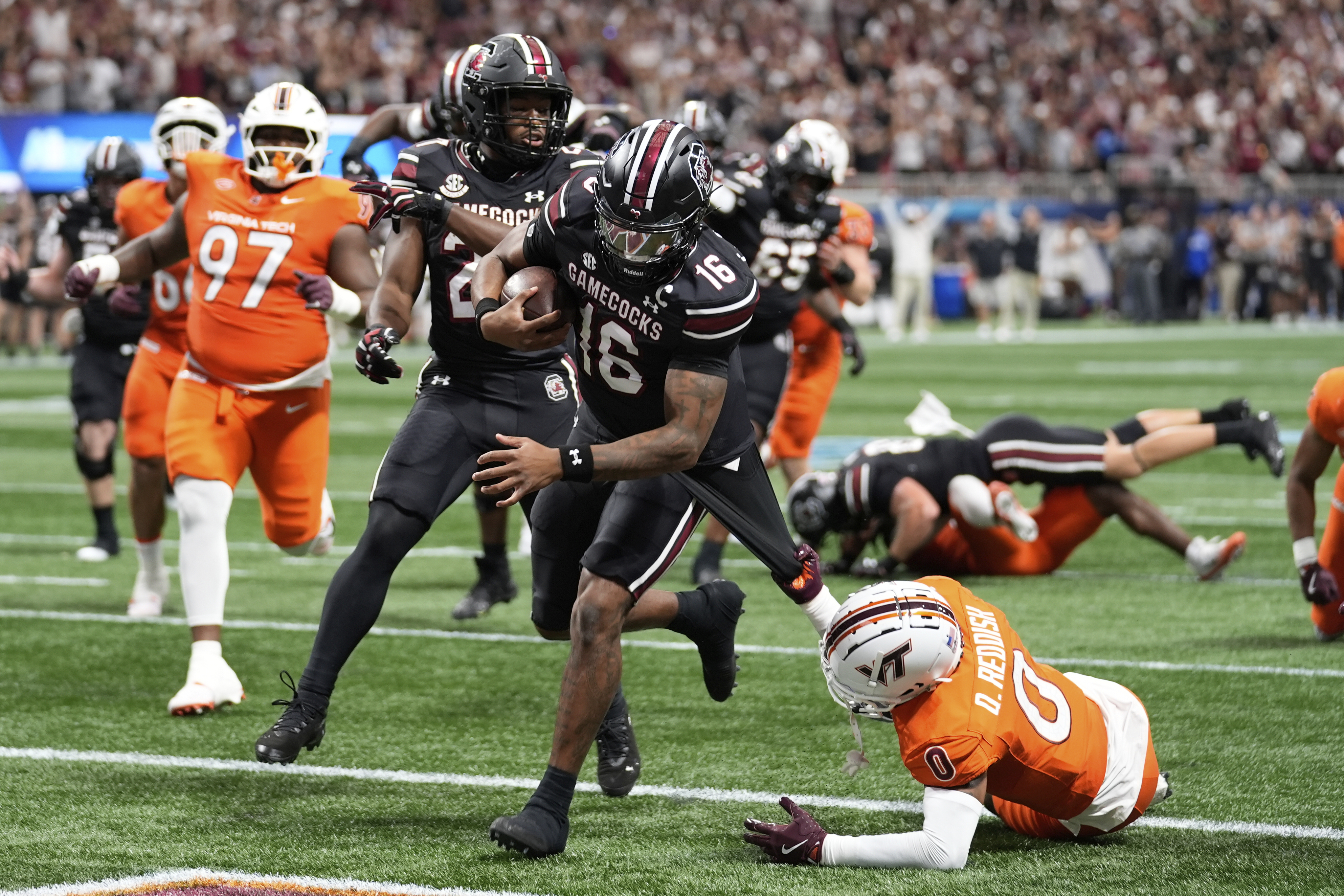 South Carolina quarterback LaNorris Sellers (16) scores against Virginia Tech safety Quentin Reddish (0) during an NCAA college football game, Sunday, Aug. 31, 2025, in Atlanta. 