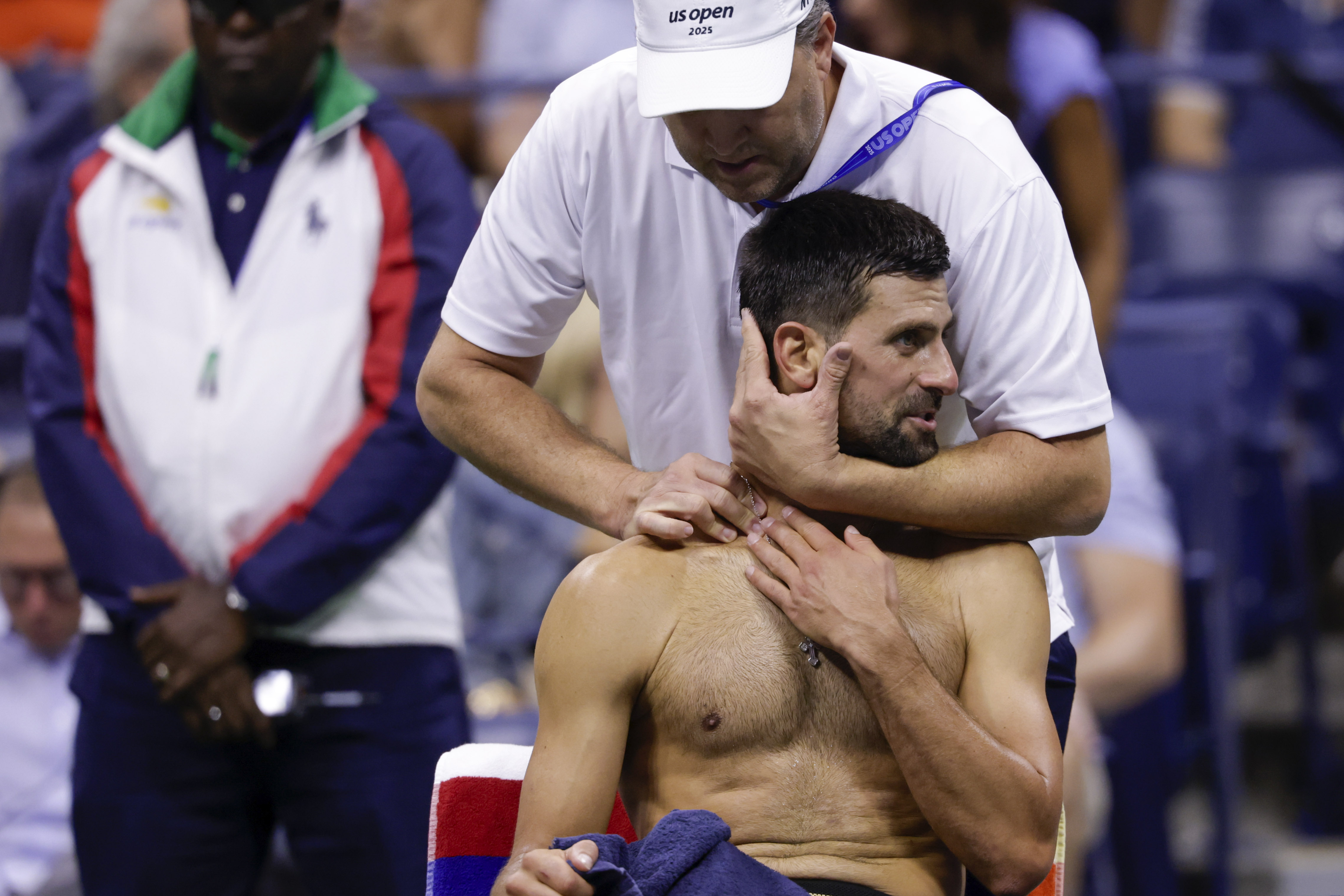 A trainer works on Novak Djokovic, of Serbia, between games against Jan-Lennard Struff, of Germany, during the fourth round of the U.S. Open tennis championships, Sunday, Aug. 31, 2025, in New York.