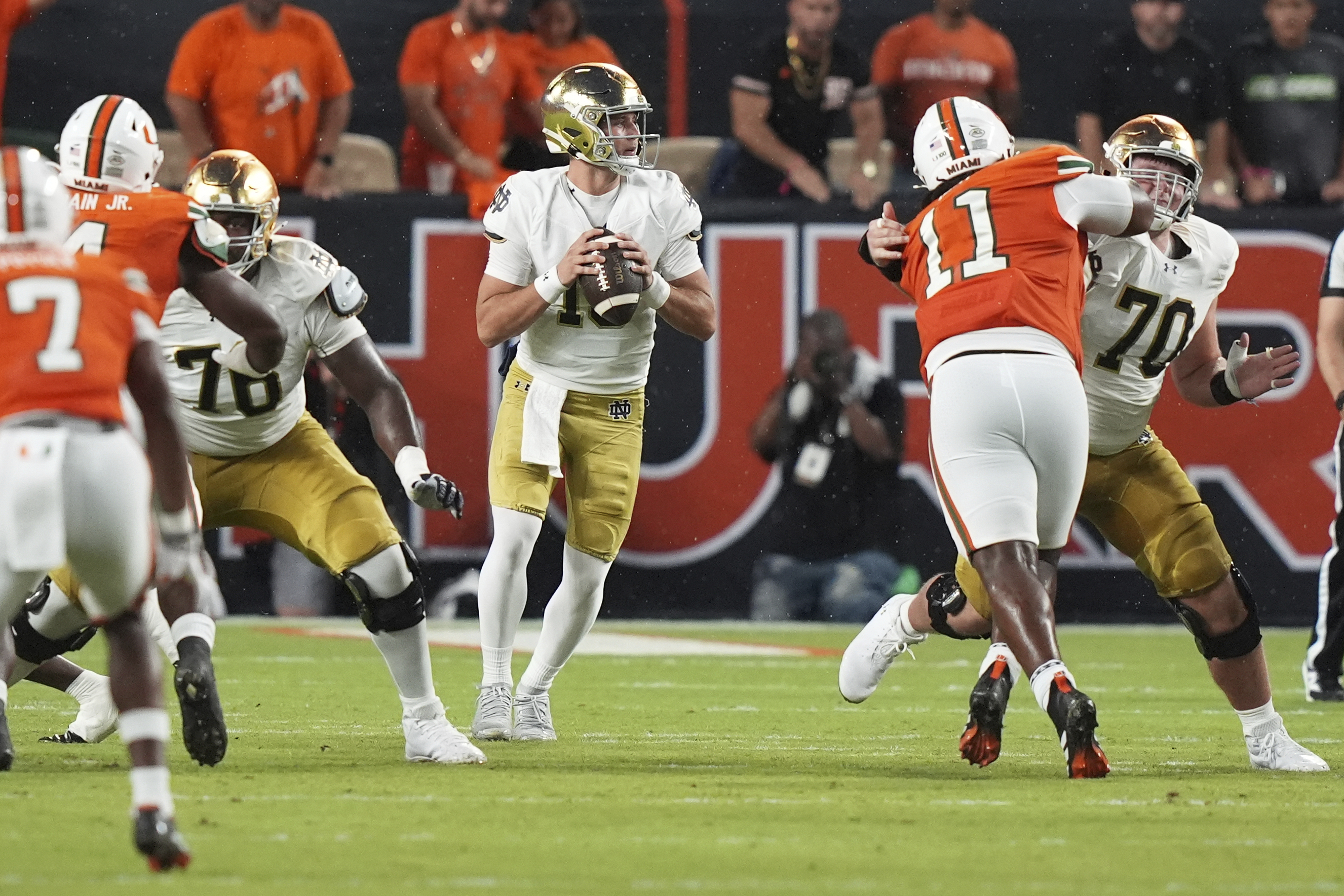 Notre Dame quarterback CJ Carr, center, looks to pass during the first half of an NCAA college football game against Miami, Sunday, Aug. 31, 2025, in Miami Gardens, Fla.