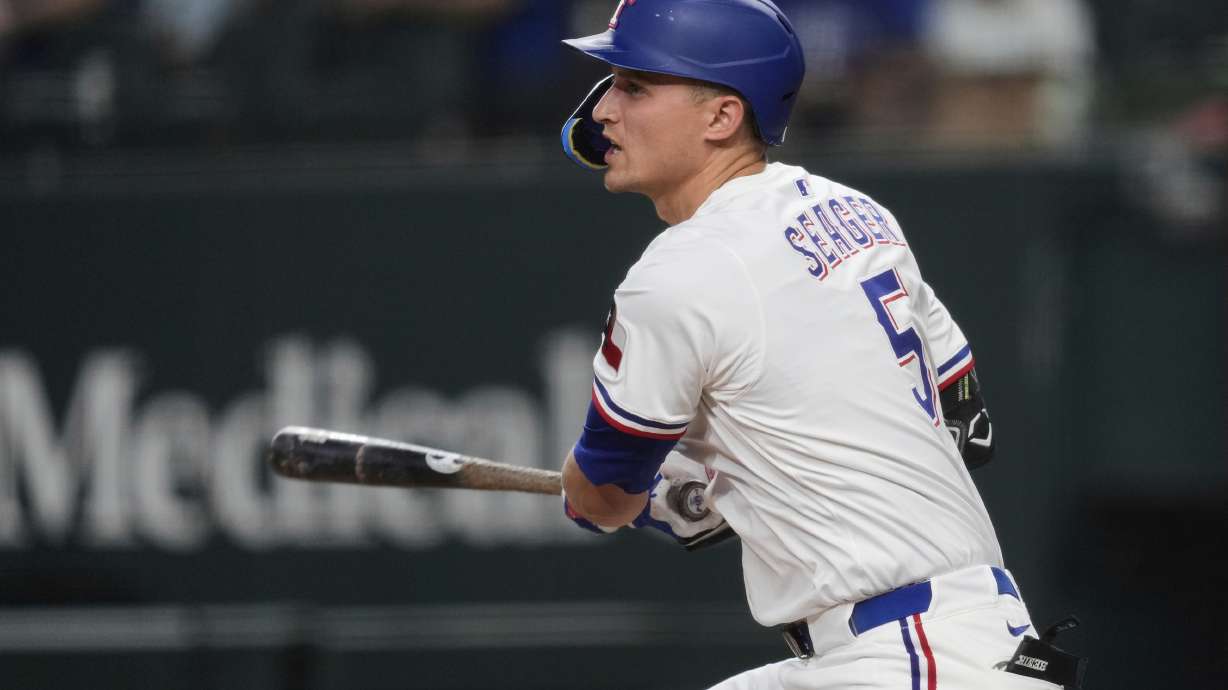 Texas Rangers' Corey Seager follows through on a single in the first inning of a baseball game against the Los Angeles Angels, Wednesday, Aug. 27, 2025, in Arlington, Texas.