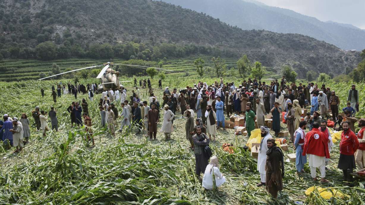 Residents gather around a military helicopter that landed to evacuate injured victims of an earthquake in eastern Afghanistan, in Mazar Dara, Kunar province, on Monday.