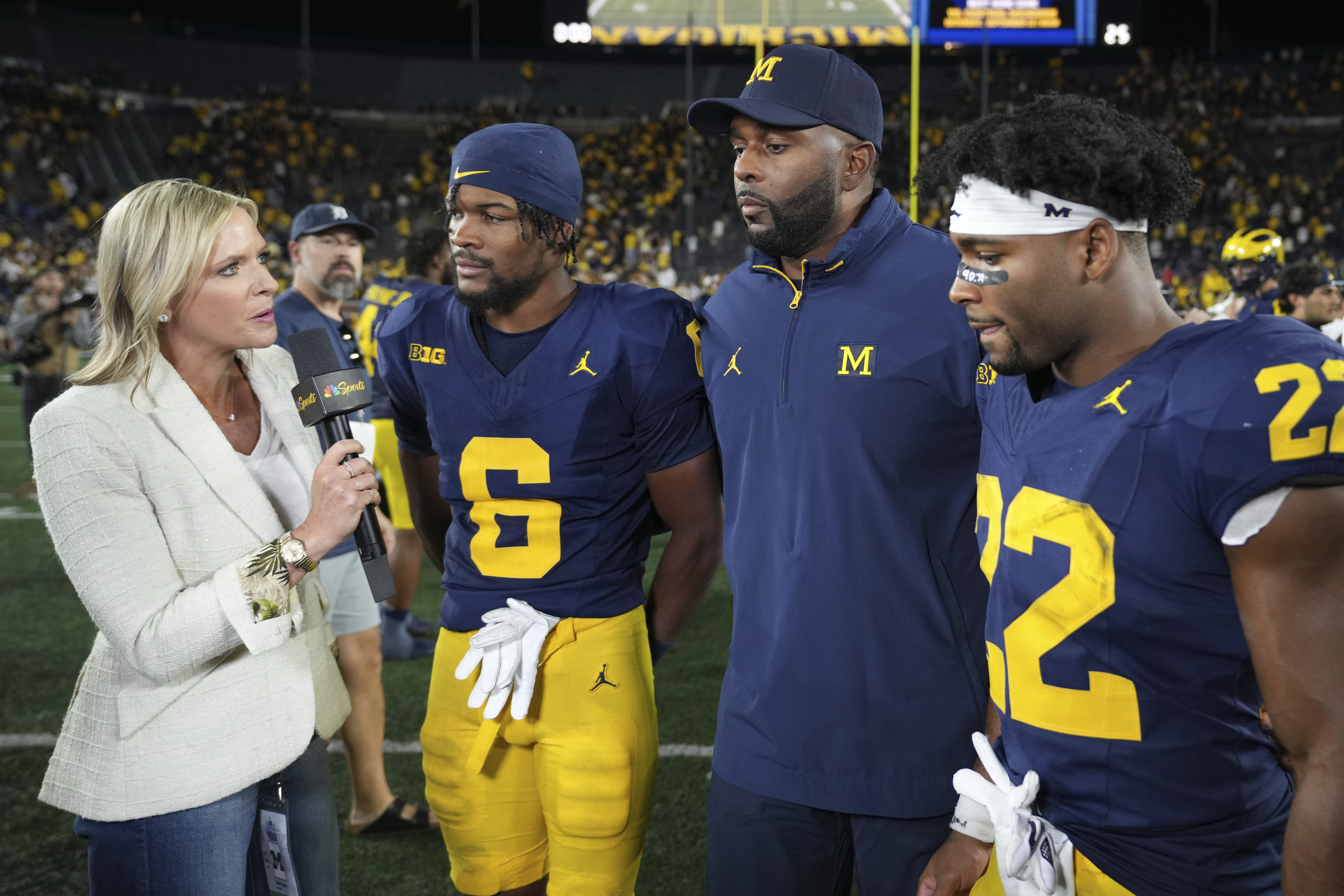 Michigan head coach Sherrone Moore, third from left, defensive back Brandyn Hillman, second from left, and running back Justice Haynes, right, speak in an interview after the team's win over New Mexico in an NCAA college football game, Saturday, Aug. 30, 2025, in Ann Arbor, Mich. 