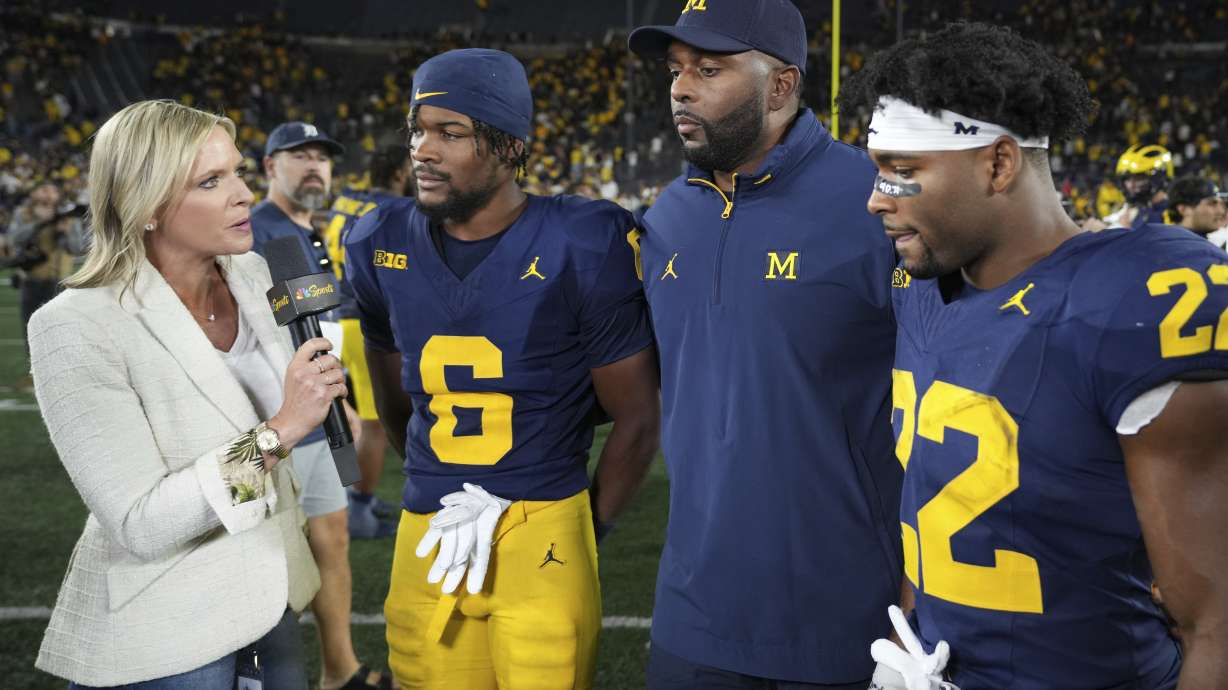 Michigan head coach Sherrone Moore, third from left, defensive back Brandyn Hillman, second from left, and running back Justice Haynes, right, speak in an interview after the team's win over New Mexico in an NCAA college football game, Saturday, Aug. 30, 2025, in Ann Arbor, Mich.