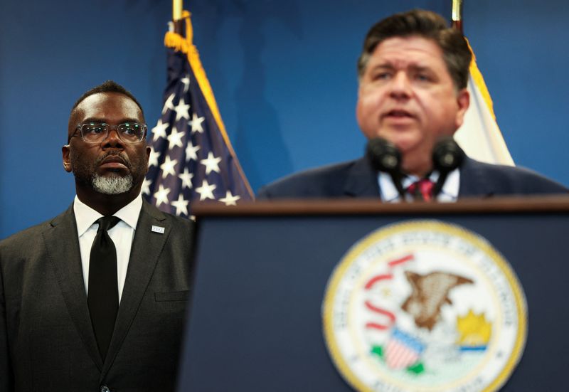 Chicago Mayor Brandon Johnson listens to Illinois Gov. JB Pritzker at a press conference on Tuesday. Johnson called Trump's deployment of the National Guard a "distraction," while Gov. Pritzker warned more federal agents were on the way.