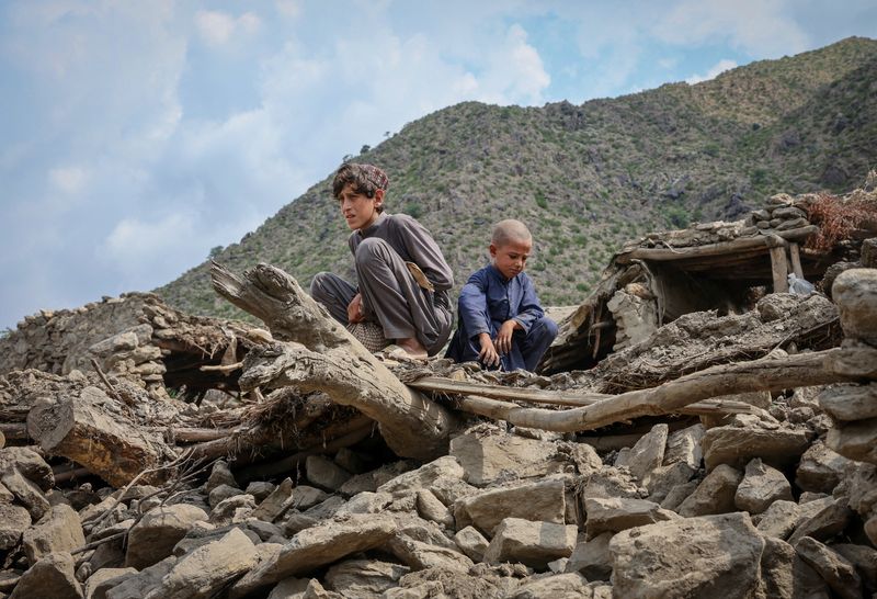 Afghan boys sit on the rubble of a house following a deadly magnitude-6 earthquake that struck Afghanistan on Sunday, at Lulam village, in Nurgal district, Kunar province, Afghanistan, Wednesday.
