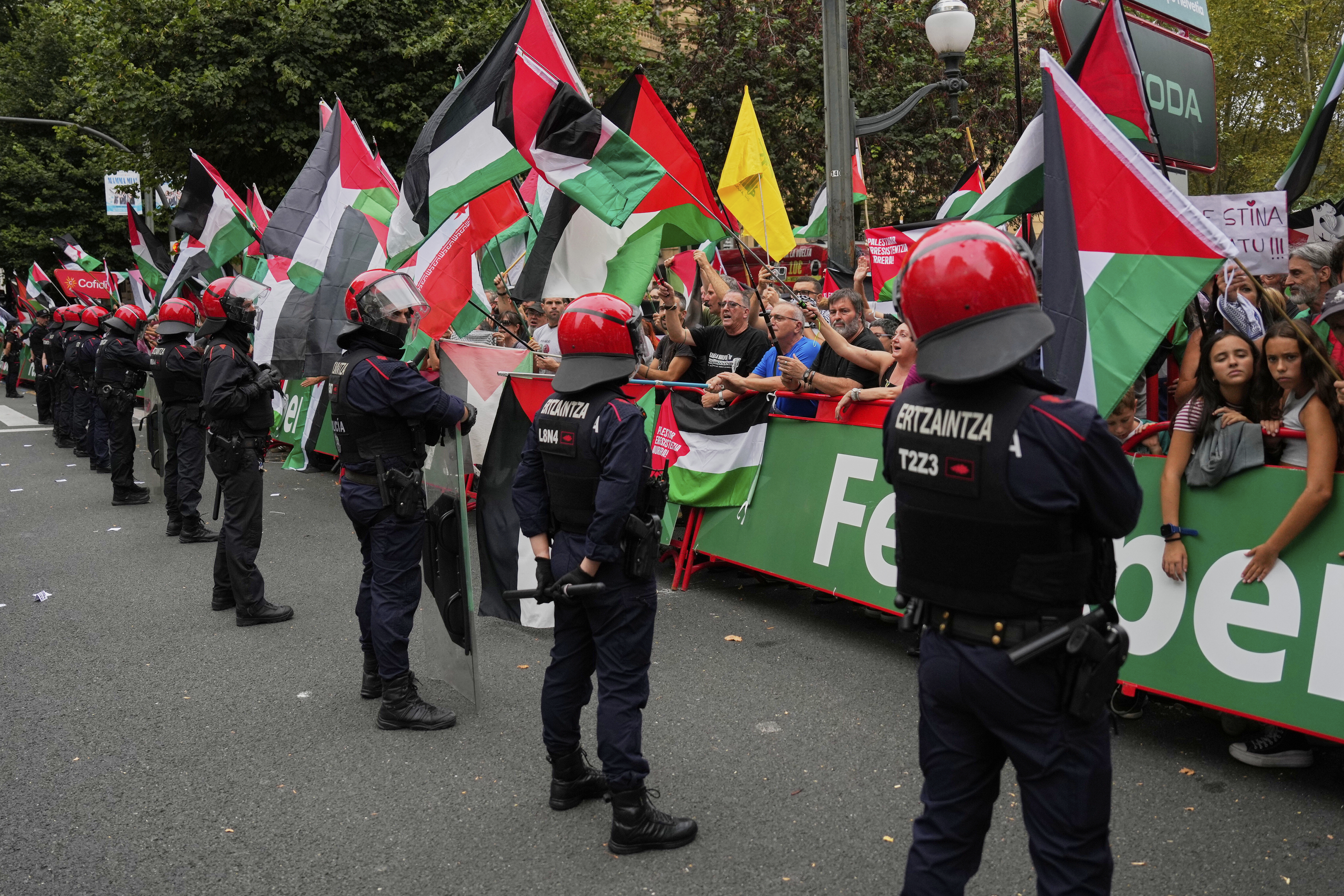 People hold Palestinian flags during the eleventh stage of the Spanish Vuelta cycling race, from Bilbao to Bilbao, Spain, Wednesday, Sept. 3, 2025. 