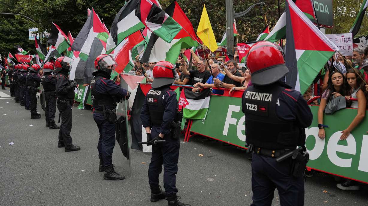 People hold Palestinian flags during the eleventh stage of the Spanish Vuelta cycling race, from Bilbao to Bilbao, Spain, Wednesday, Sept. 3, 2025.