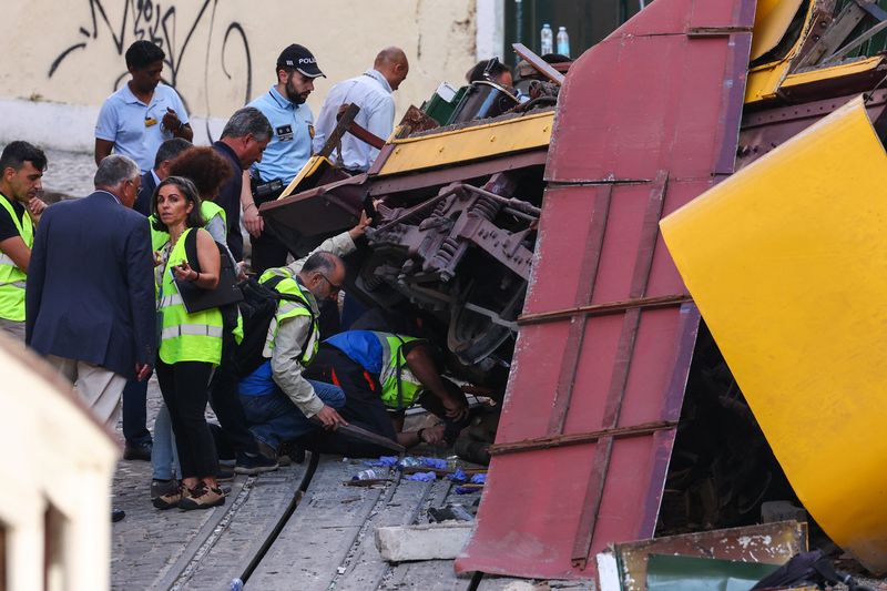People work at the site of the accident after Gloria funicular railway car, a popular tourist attraction, derailed and crashed, resulting in multiple casualties, in Lisbon, Portugal, Thursday.