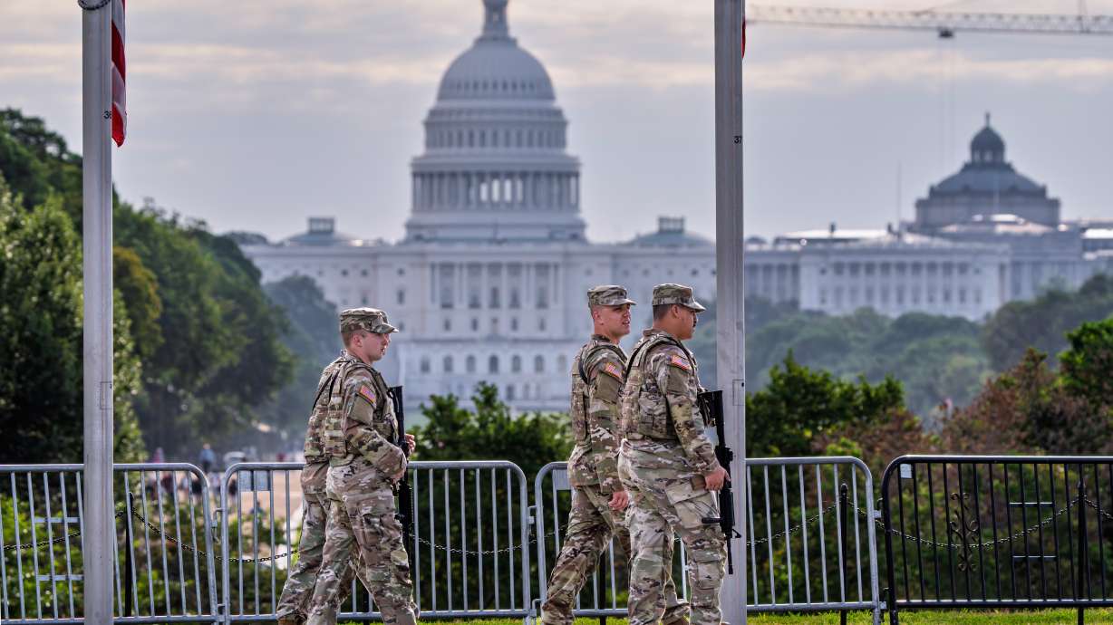 National Guard troops patrol the grounds of the Washington Monument with the Capitol as part of President Donald Trump's order to impose federal law enforcement in the nation's capital, in Washington, Aug. 28.