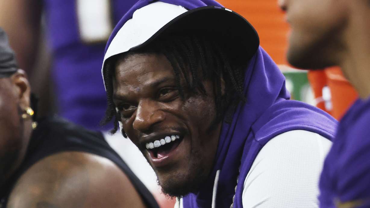 Baltimore Ravens quarterback Lamar Jackson laughs as he talks with teammates on the sideline in the first half of a preseason NFL football game against the Dallas Cowboys Saturday, Aug. 16, 2025, in Arlington, Texas.