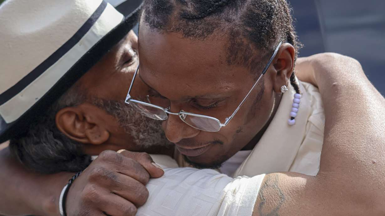 After a judge found him innocent of a 1998 murder, Bryan Hooper, Sr., left, embraces his son Bryan Hooper, Jr., outside Stillwater Prison on Thursday in Bayport, Minn.