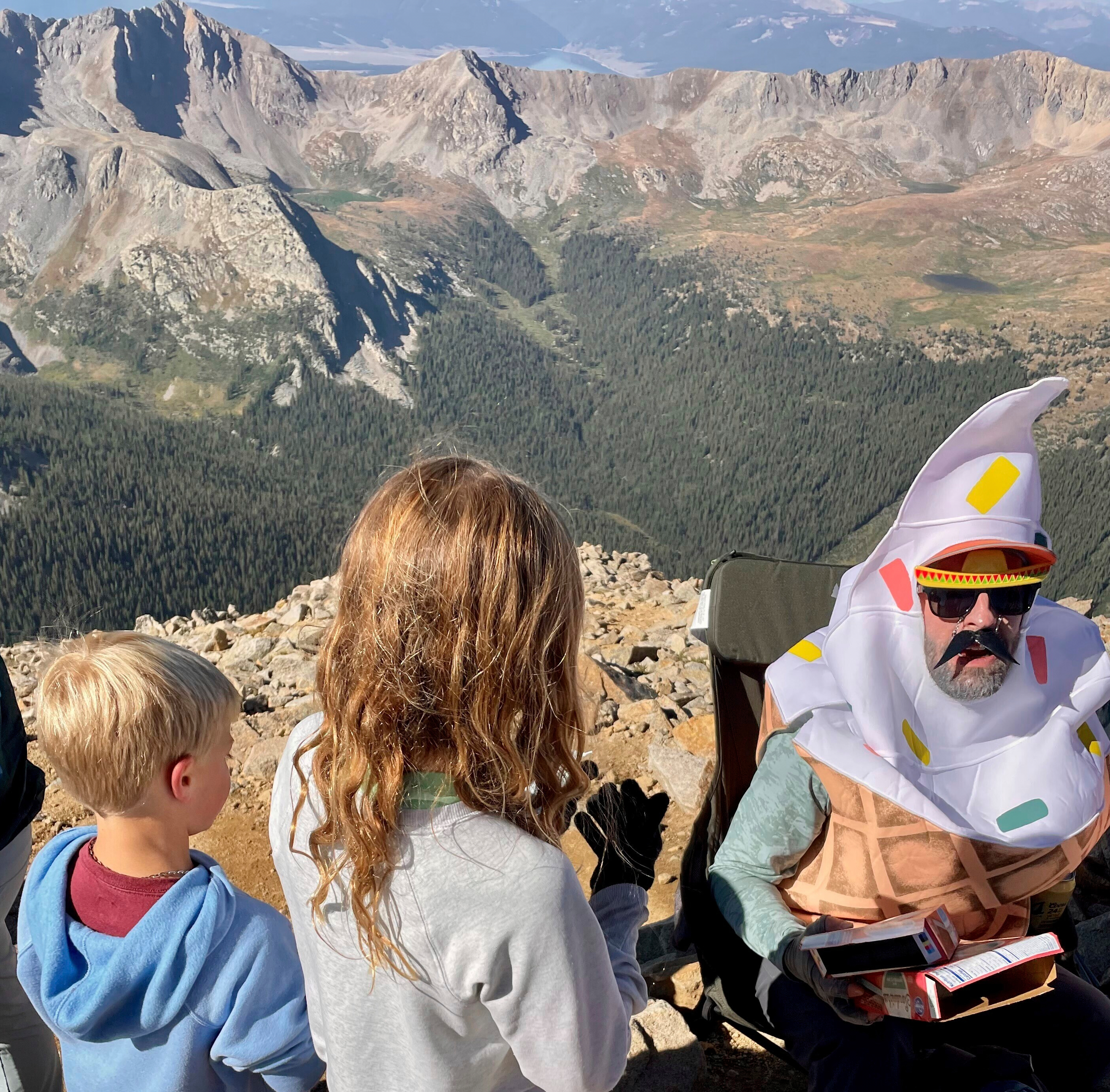A man shares ice cream he carried up Huron Peak packed in dry ice with fellow hikers in Chaffee County, Colo., Aug. 31.