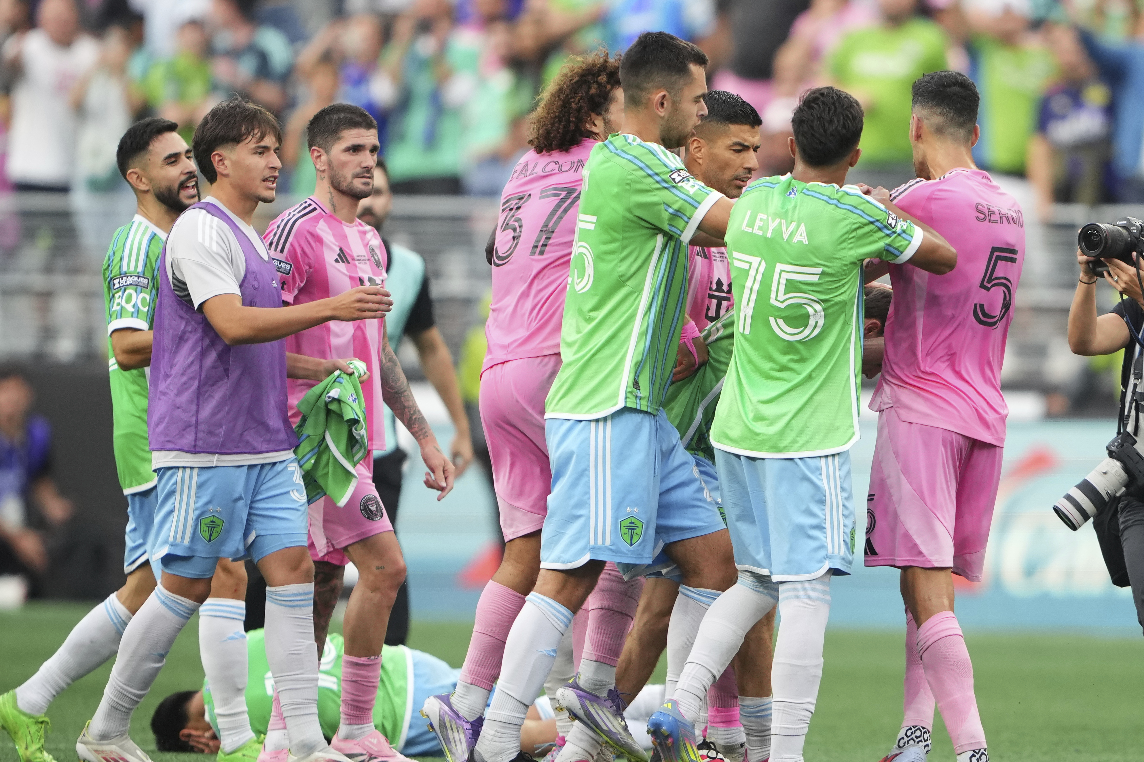 Seattle Sounders midfielder Obed Vargas, bottom left, lies on the ground after being pushed during an altercation against Inter Miami, including forward Luis Suárez and midfielder Sergio Busquets (5) after the Sounders won a Leagues Cup final soccer match Sunday, Aug. 31, 2025, in Seattle. 