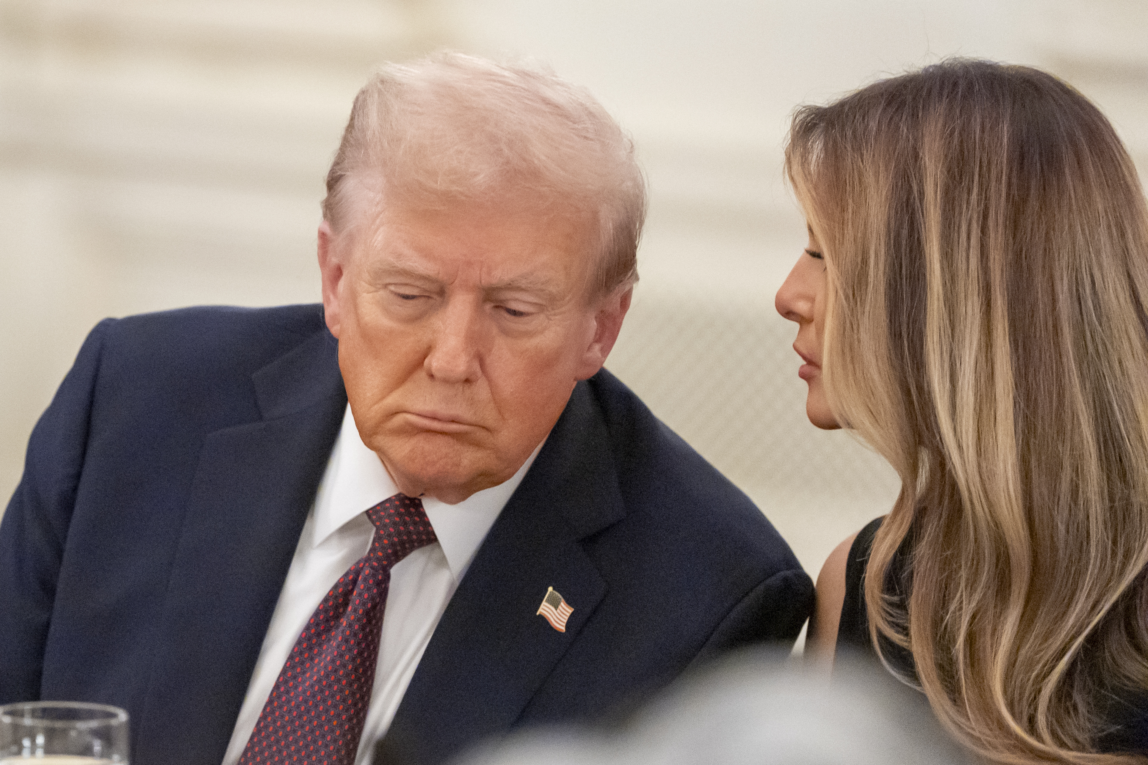 President Donald Trump listens as first lady Melania Trump repeats a question for him during a dinner in the State Dinning Room of the White House, Thursday, Sept. 4, 2025, in Washington. 