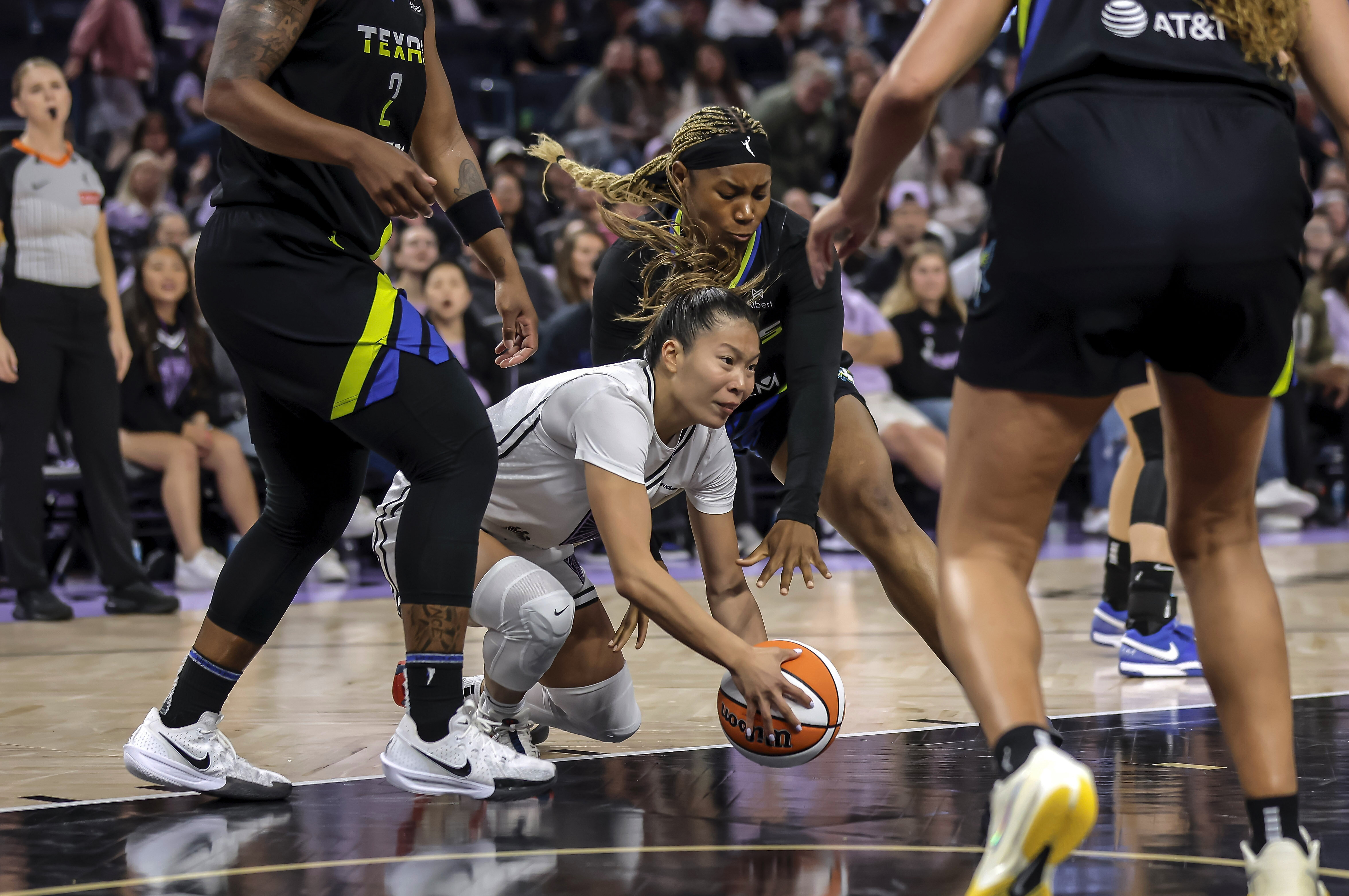 Golden State Valkyries' Kaitlyn Chen, center front, dives for the ball in the first half of a WNBA basketball game against the Dallas Wings in San Francisco, Thursday, Sept. 4, 2025.