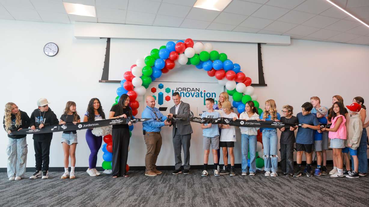 Juniper Elementary students watch as America First's Brett Greenwell and Principal Kaleb Yates cut the ribbon to celebrate the opening of the Jordan Innovation Lab at Juniper Elementary School in Herriman on Friday.