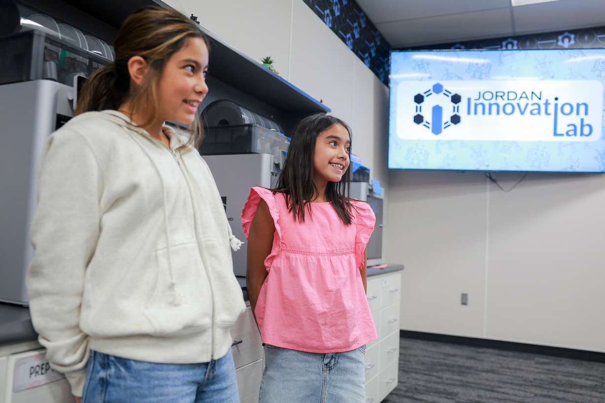 Mila Levine, left, and Diana Nieves, right, speak with a teacher while waiting for their 3D prints to finish in the Jordan Innovation Lab at Juniper Elementary School in Herriman on Friday.