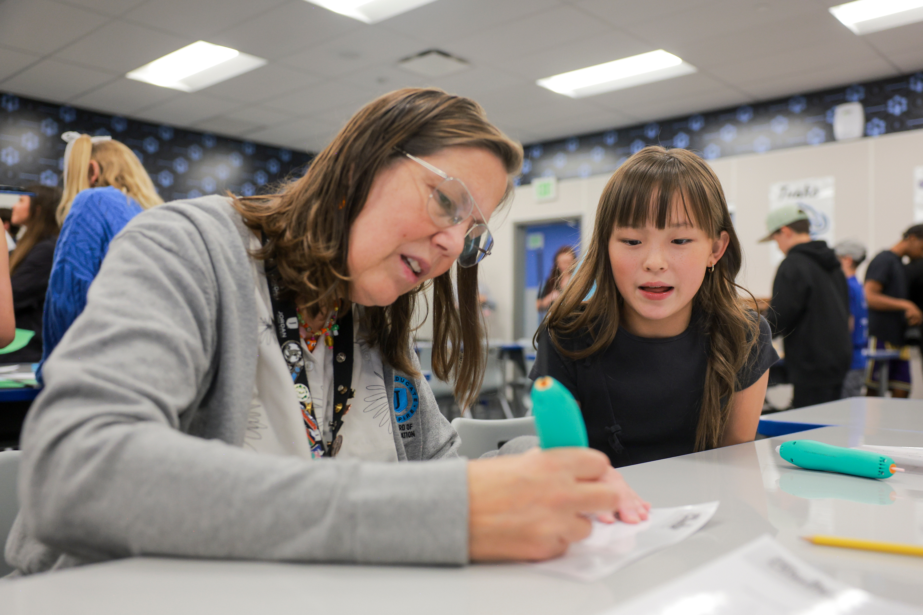 Juniper Elementary student Mia Stobbe, right, teaches Jordan School Board member Lisa Dean, left, how to use a 3D printing pen in the Jordan Innovation Lab at Juniper Elementary School in Herriman on Friday.