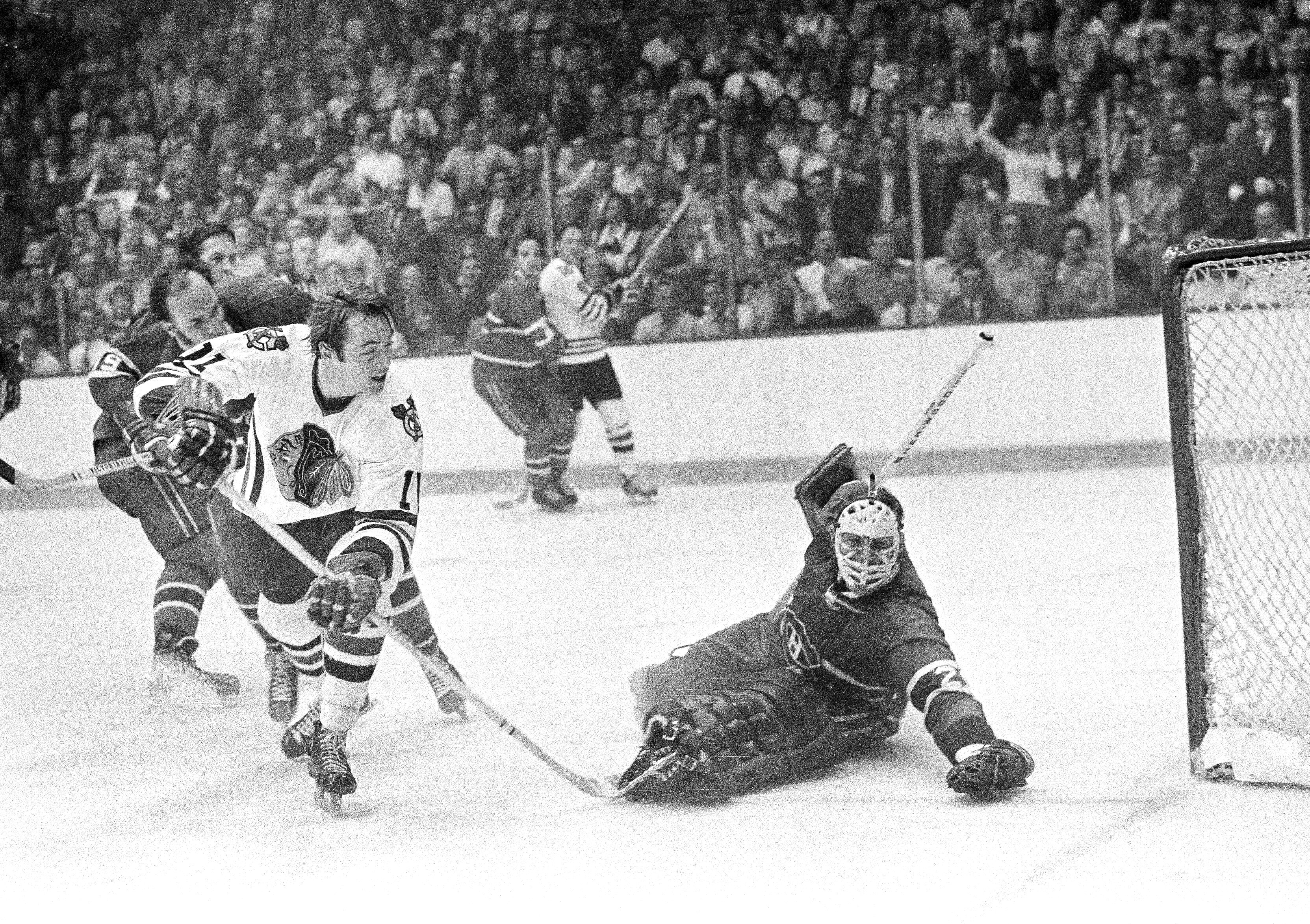 FILE - Montreal Canadiens goalie Ken Dryden makes a save off the stick of Boston Bruins Bob Schmautz, during their Stanley Cup hockey playoff game at Boston Garden, May 18, 1978.
