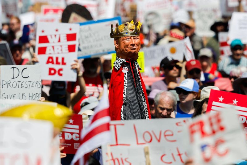 A demonstrator holds a representation of President Donald Trump wearing a crown during the "We Are All D.C." march in Washington Saturday. Trump was not present in Washington during the protests.
