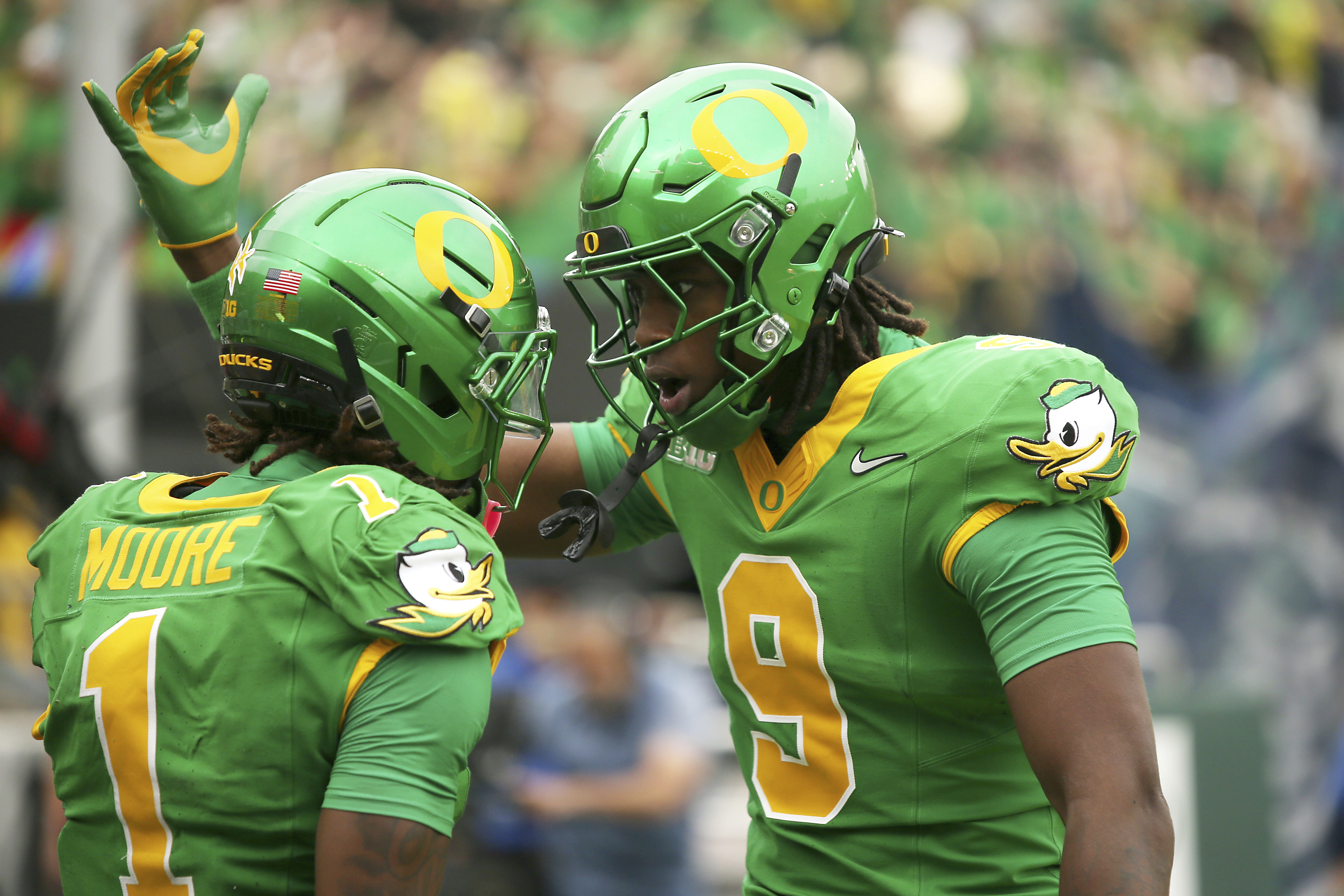 Oregon wide receiver Dakorien Moore (1) is congratulated after his touchdown by tight end Jamari Johnson (9) during the first half of an NCAA college football game against Oklahoma State, Saturday, Sept. 6, 2025, in Eugene, Ore.
