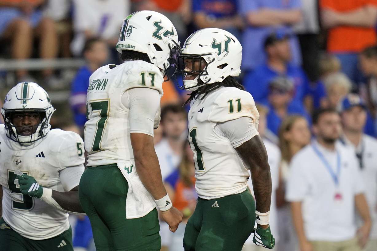 South Florida wide receiver Keshaun Singleton (11) celebrates his 66-yard touchdown against Florida with quarterback Byrum Brown (17) during the second half of an NCAA college football game, Saturday, Sept. 6, 2025, in Gainesville, Fla.