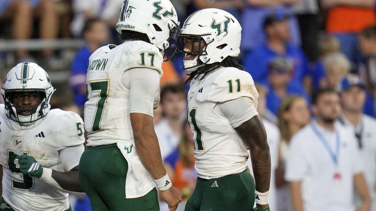 South Florida wide receiver Keshaun Singleton (11) celebrates his 66-yard touchdown against Florida with quarterback Byrum Brown (17) during the second half of an NCAA college football game, Saturday, Sept. 6, 2025, in Gainesville, Fla.
