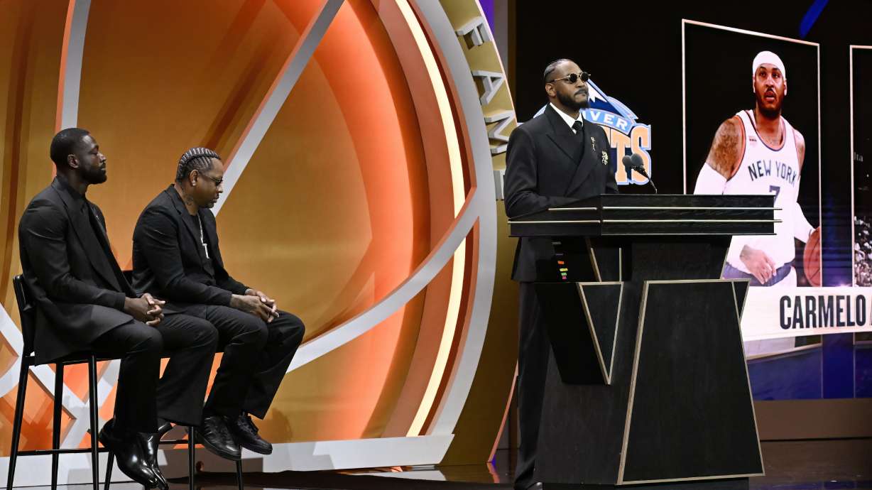 Carmelo Anthony, right, speaks During his enshrinement in the Basketball Hall of Fame as Dwyane Wade, left, and Allen Iverson listen, Saturday, Sept. 6, 2025, in Springfield, Mass.