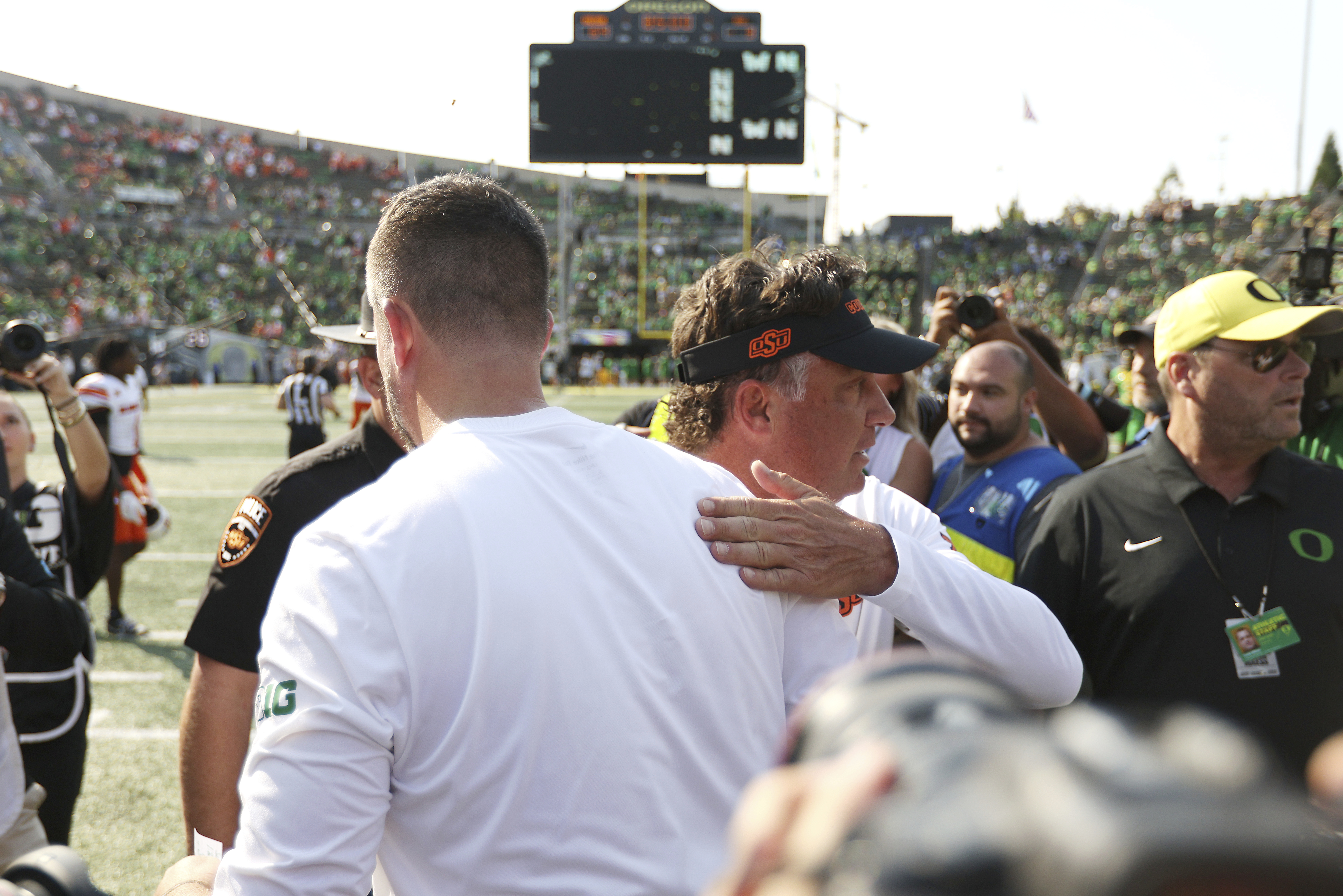 Oregon head coach Dan Lanning, left, greets Oklahoma State head coach Mike Gundy, center right, after an NCAA college football game, Saturday, Sept. 6, 2025, in Eugene, Ore. 