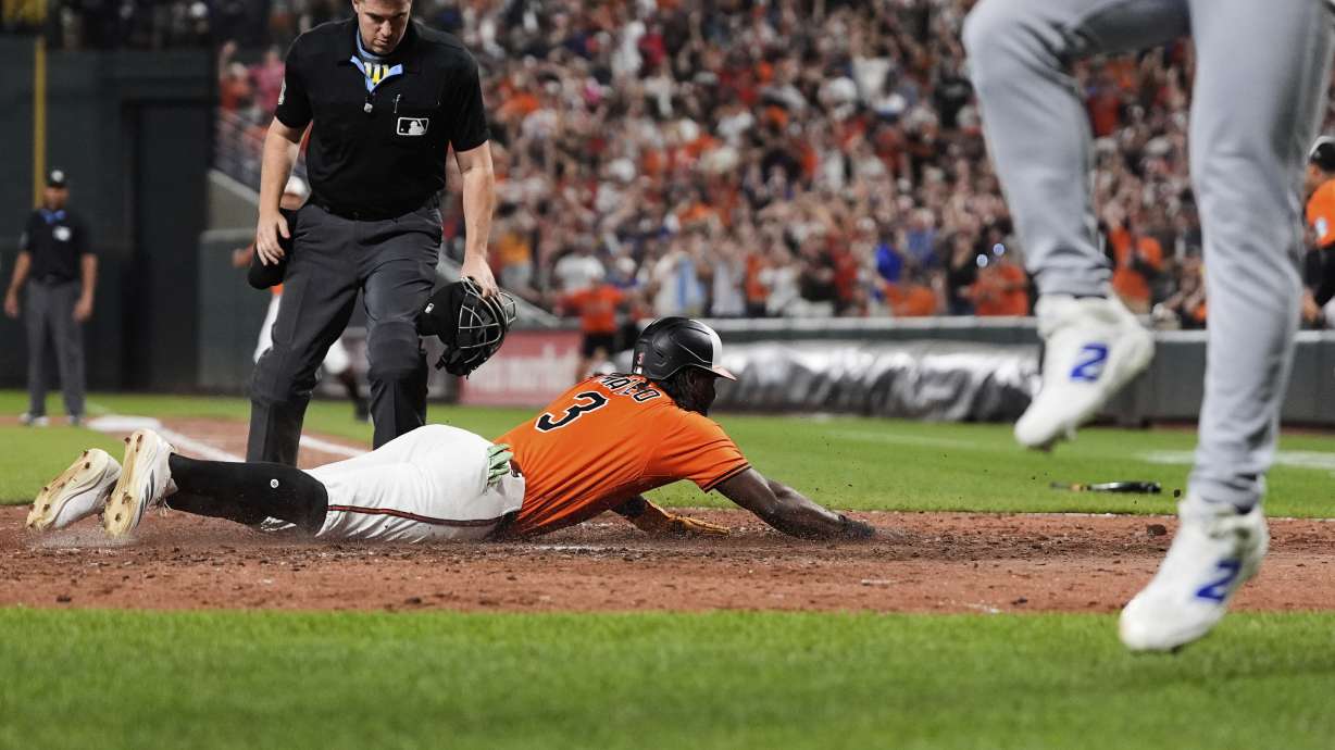 Baltimore Orioles' Jorge Mateo (3) slides into home plate to score on a walk-off single hit by Emmanuel Rivera during the ninth inning of a baseball game against the Los Angeles Dodgers, Saturday, Sept. 6, 2025, in Baltimore.
