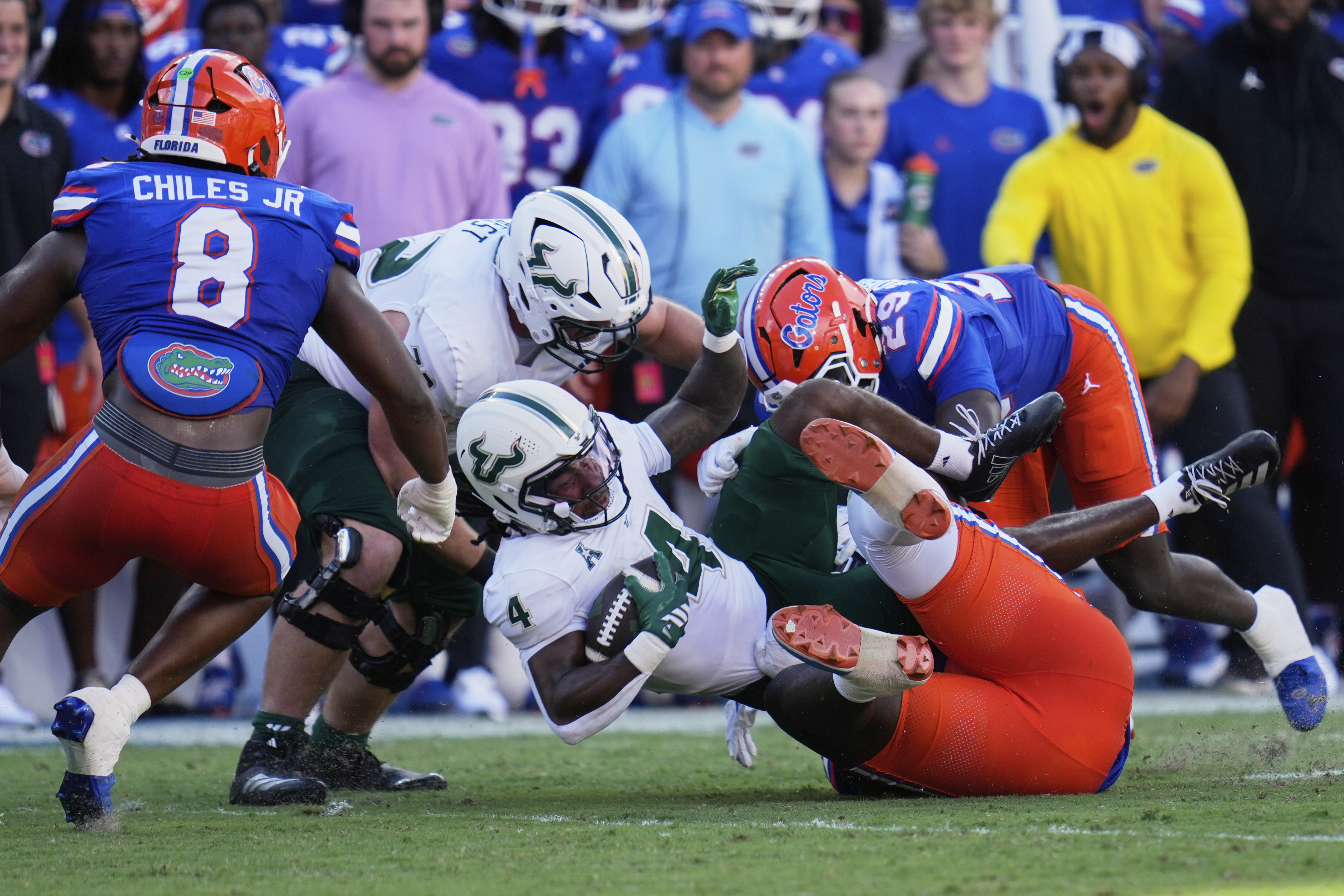 South Florida running back Sam Franklin (4) is stopped by Florida linebacker Jaden Robinson, right, and linebacker Aaron Chiles (8) during the first half of an NCAA college football game, Saturday, Sept. 6, 2025, in Gainesville, Fla. 