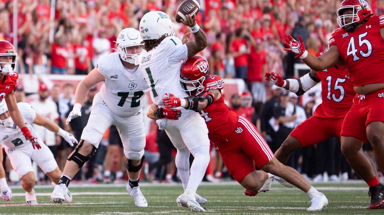 Cal Poly quarterback Ty Dieffenbach is hit by a Utah defender while attempting a throw in a game on Sept. 6, 2025.