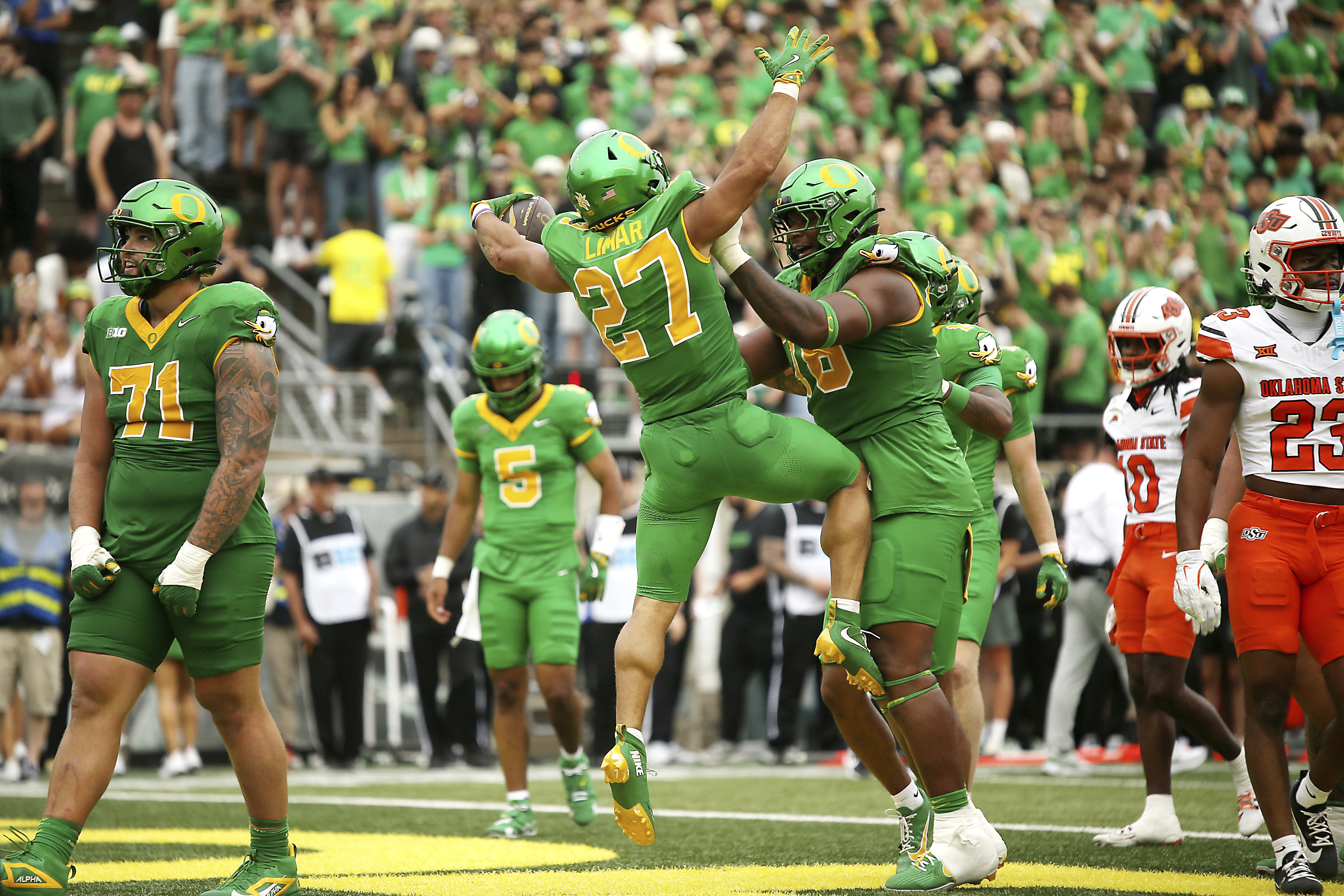 Oregon running back Jayden Limar (27) celebrates after his touchdown with offensive lineman Isaiah World, center right, during the first half of an NCAA college football game against Oklahoma State, Saturday, Sept. 6, 2025, in Eugene, Ore.