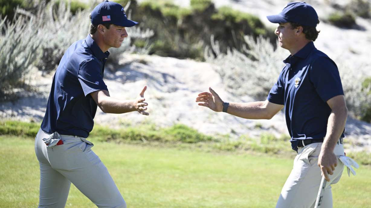The USA team's Mason Howell, left, shakes hands with Jacob Modleski during Walker Cup golf matches against the Great Britain and Ireland team at Cypress Point Club on Sunday, Sept. 7, 2025, in Pebble Beach, Calif.