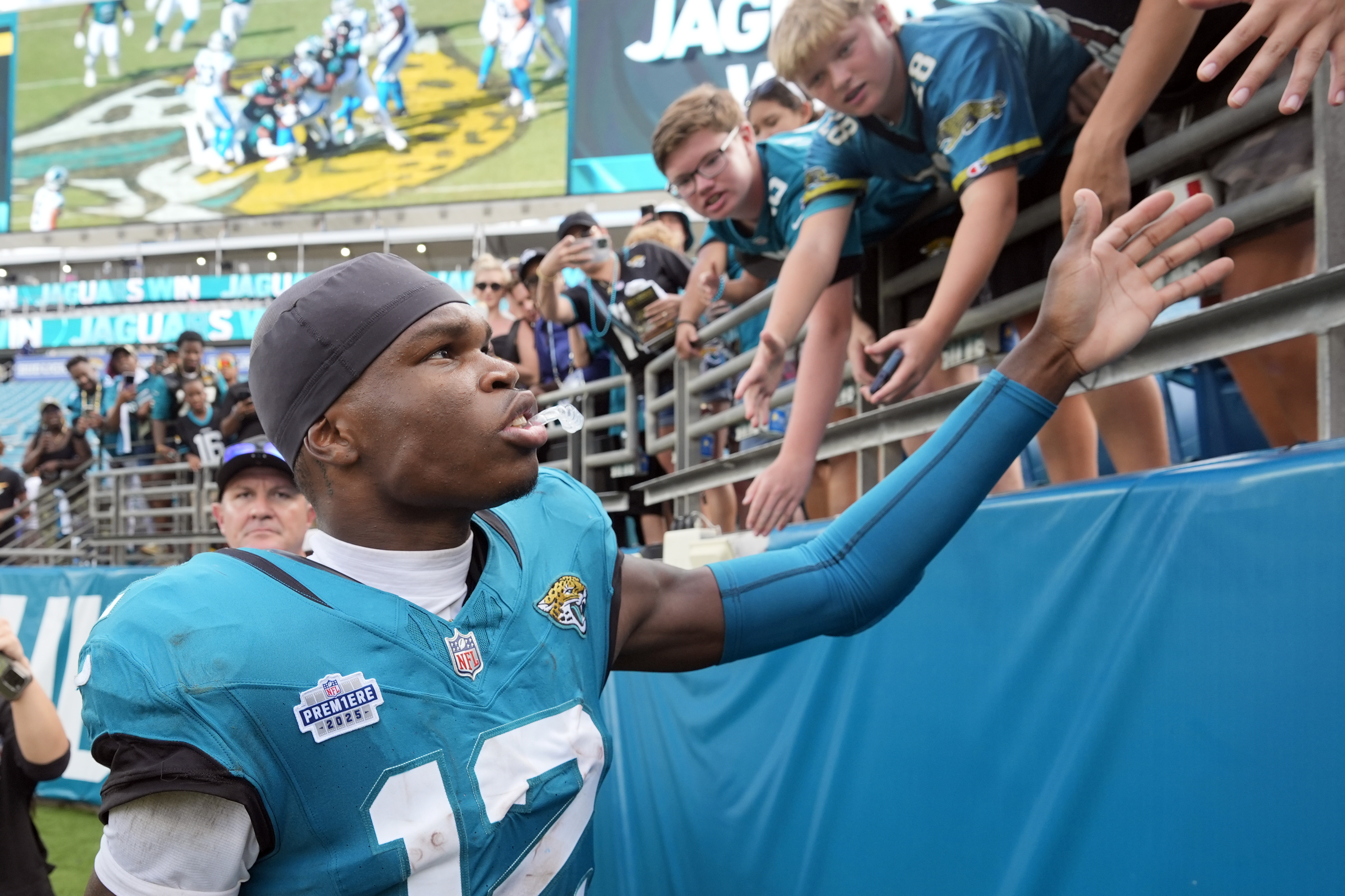 Jacksonville Jaguars wide receiver Travis Hunter (12) signs greets fans after an NFL football game against the Carolina Panthers, Sunday, Sept. 7, 2025, in Jacksonville, Fla. 